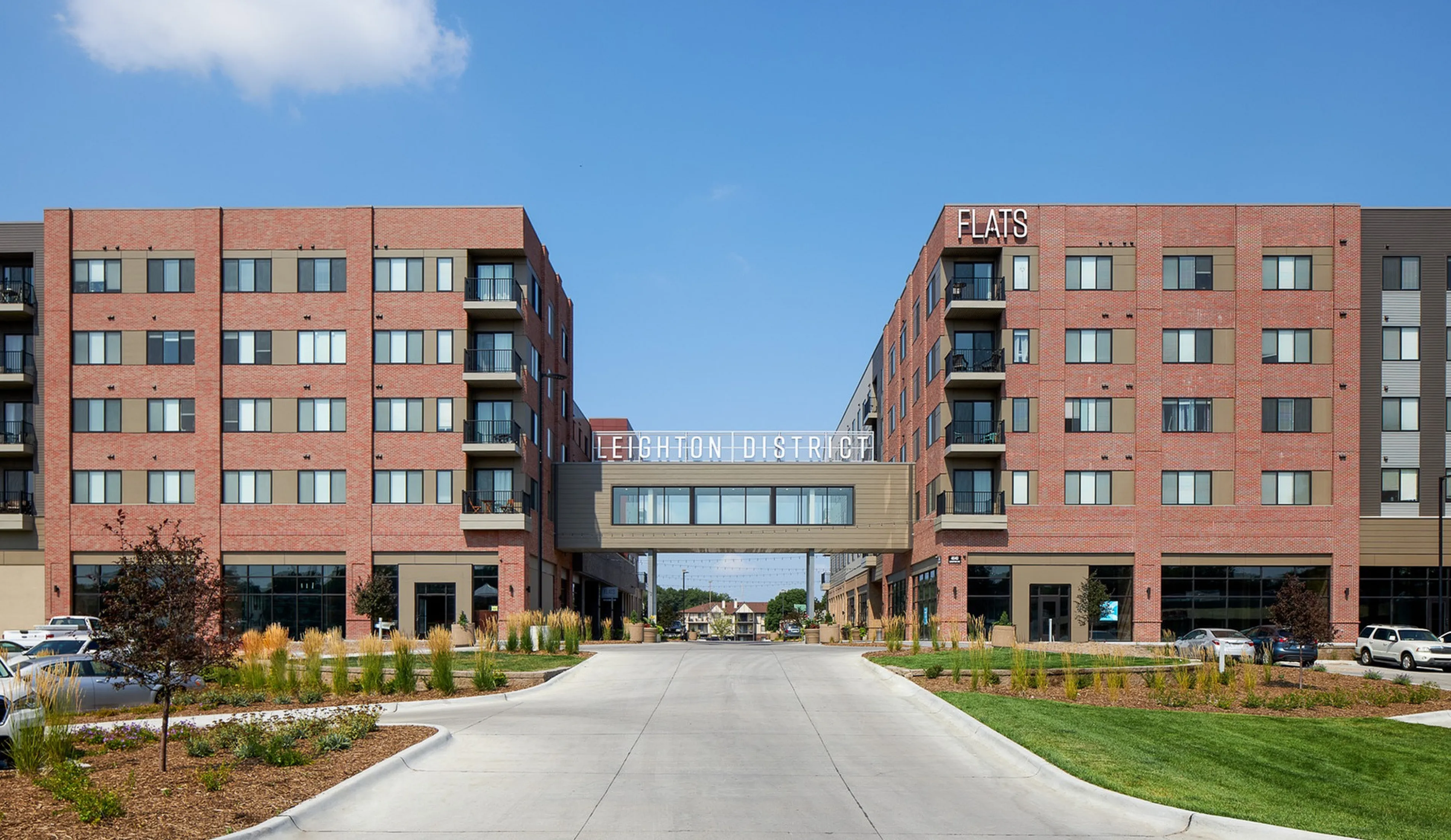 Modern urban apartment complex featuring red brick facade, spacious units, and a connecting skybridge in Leighton District.