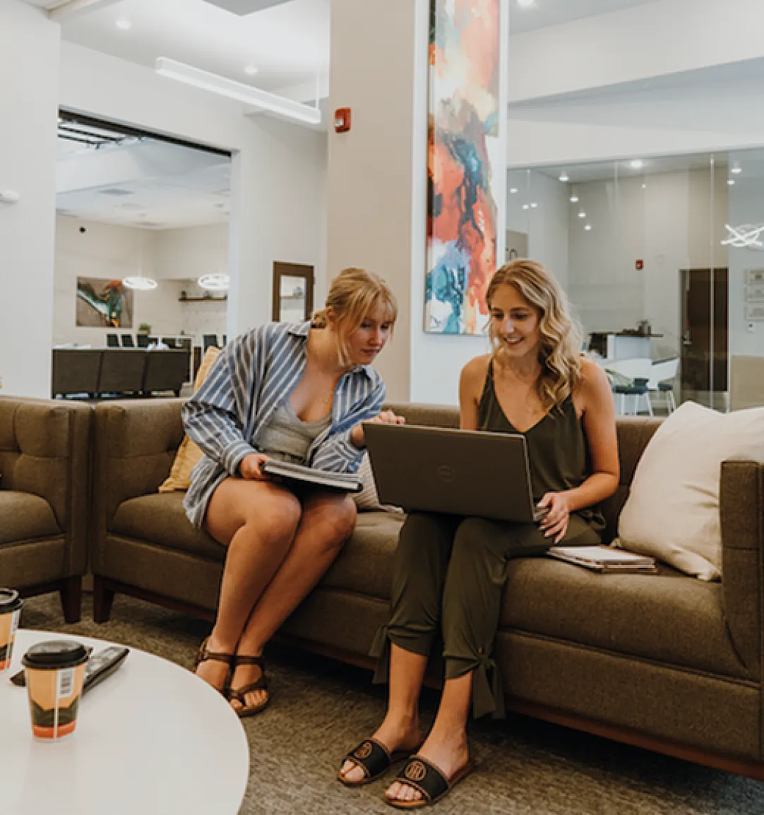 Modern open-concept space with comfortable seating, vibrant artwork, and warm lighting perfect for collaborative work.