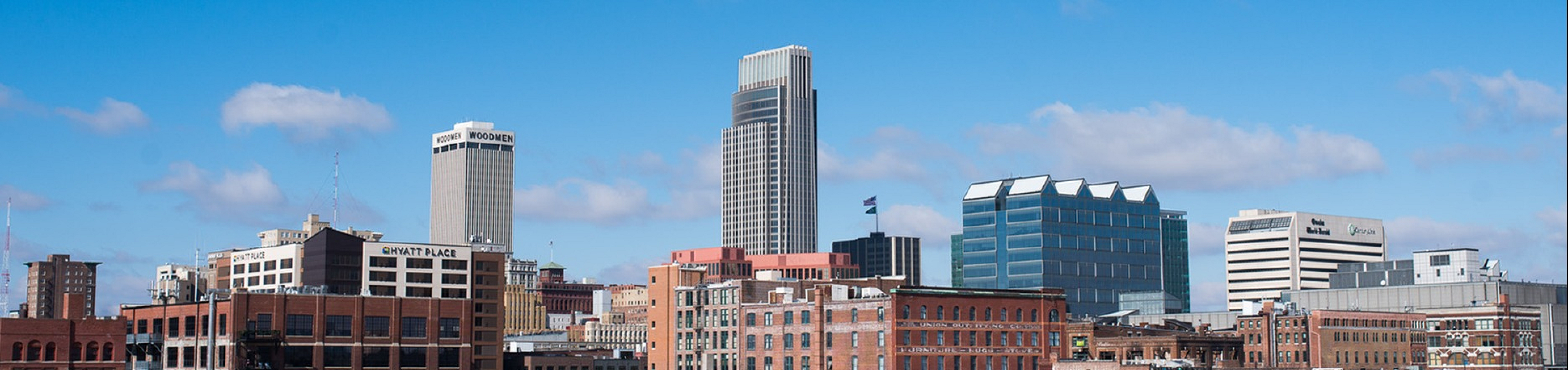 Vibrant urban skyline with modern skyscrapers and historic architecture under a clear blue sky, showcasing city life and development.