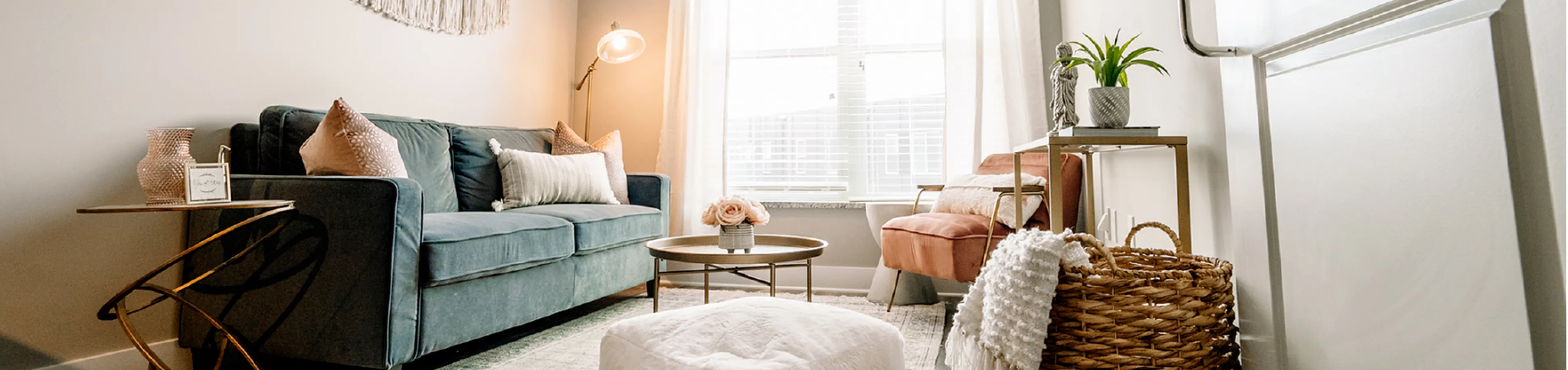 Chic living room with a plush teal sofa, stylish side table, and warm natural light, ideal for relaxation.