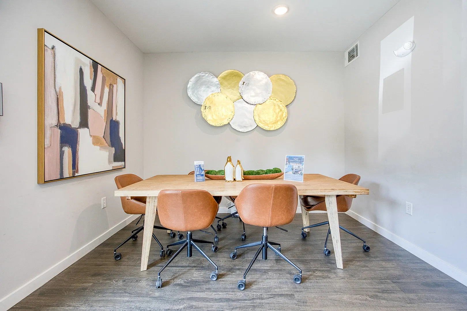 Chic dining area with modern art, stylish leather chairs, and a contemporary wooden table, perfect for entertaining.