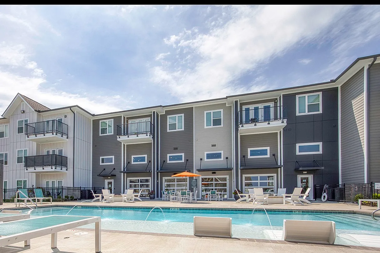 Modern apartments with private balconies overlooking a luxurious pool area, perfect for relaxation and outdoor enjoyment.