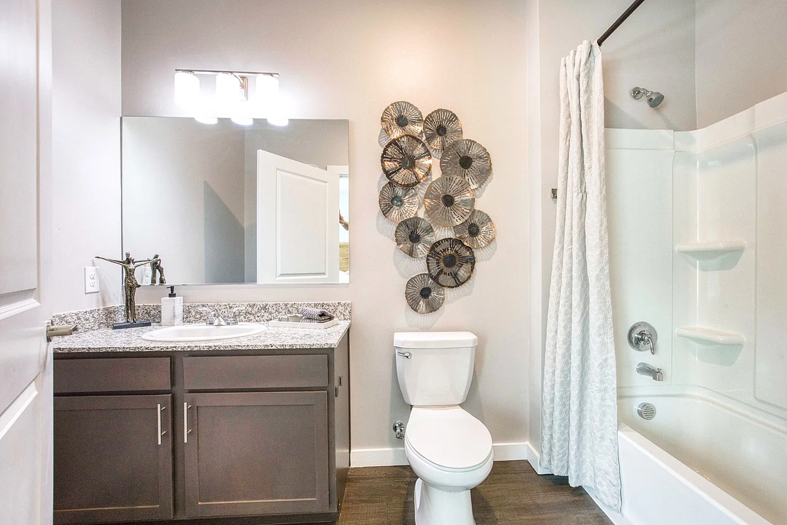 Elegant bathroom with sleek vanity, modern fixtures, and unique wall art, offering a serene and stylish space.