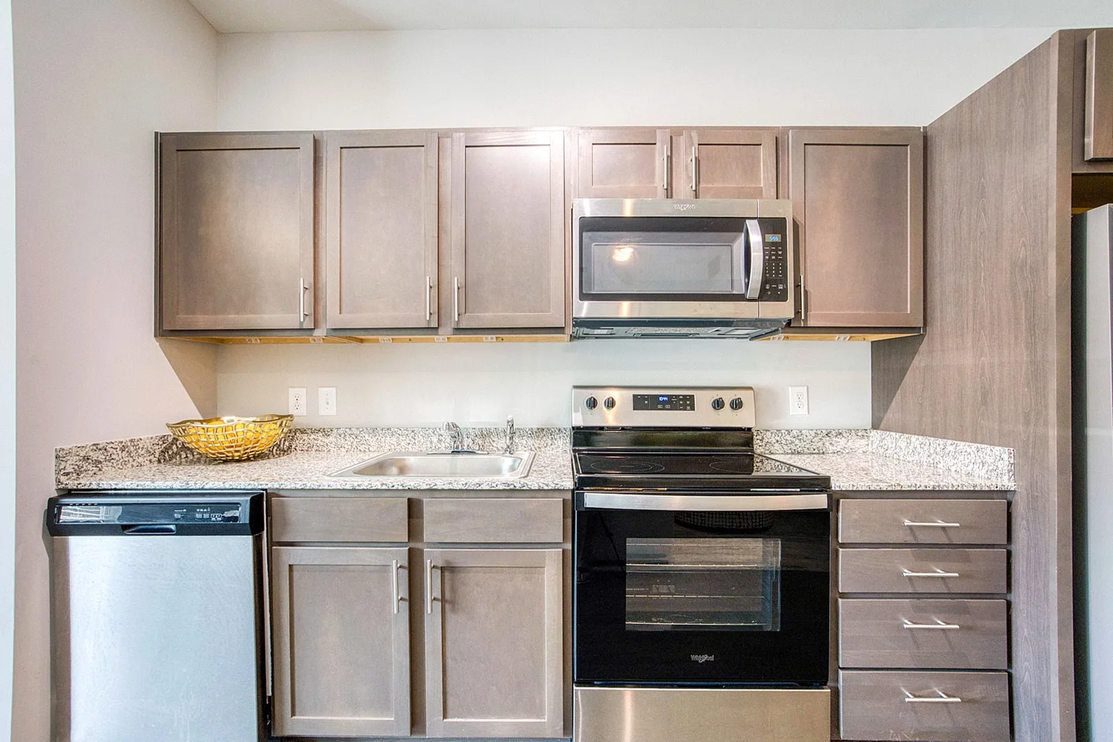 Modern kitchen with sleek stainless steel appliances, elegant granite countertops, and stylish cabinetry.