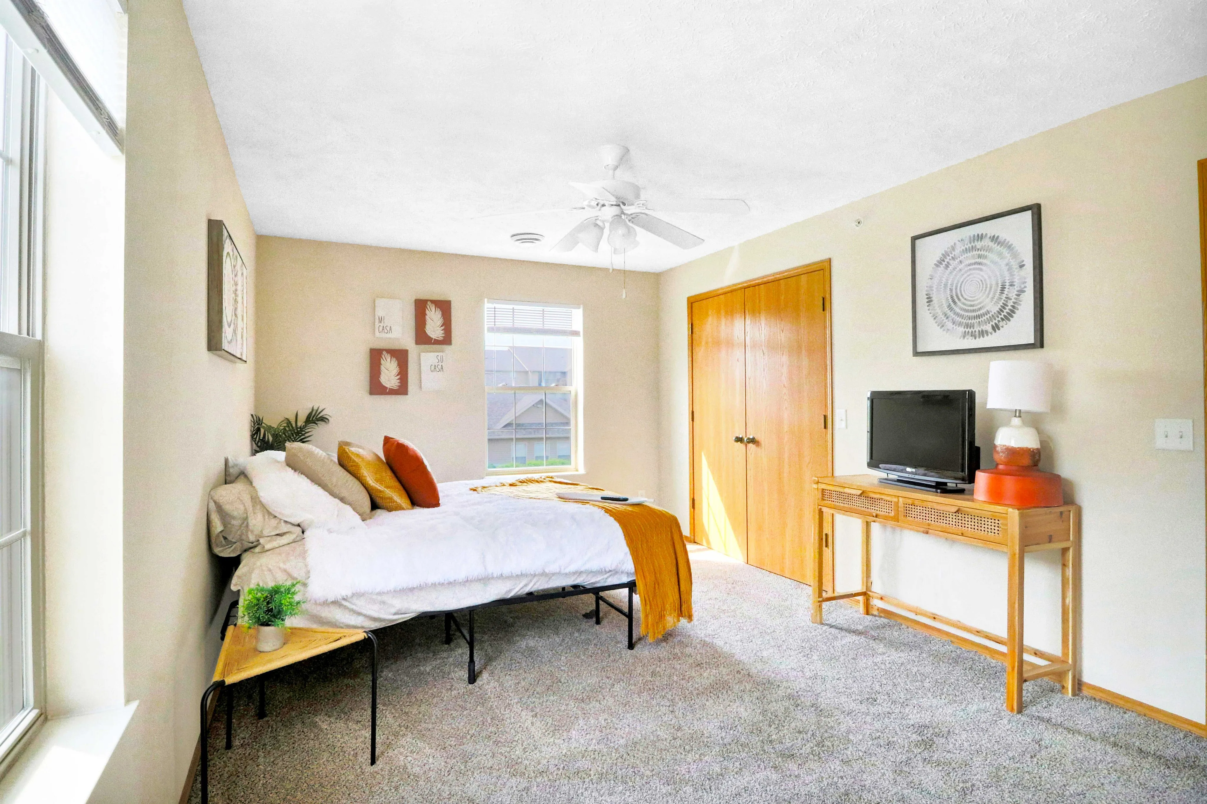 Bright and cozy bedroom with modern decor, featuring a comfortable bed, stylish artwork, and ample natural light.