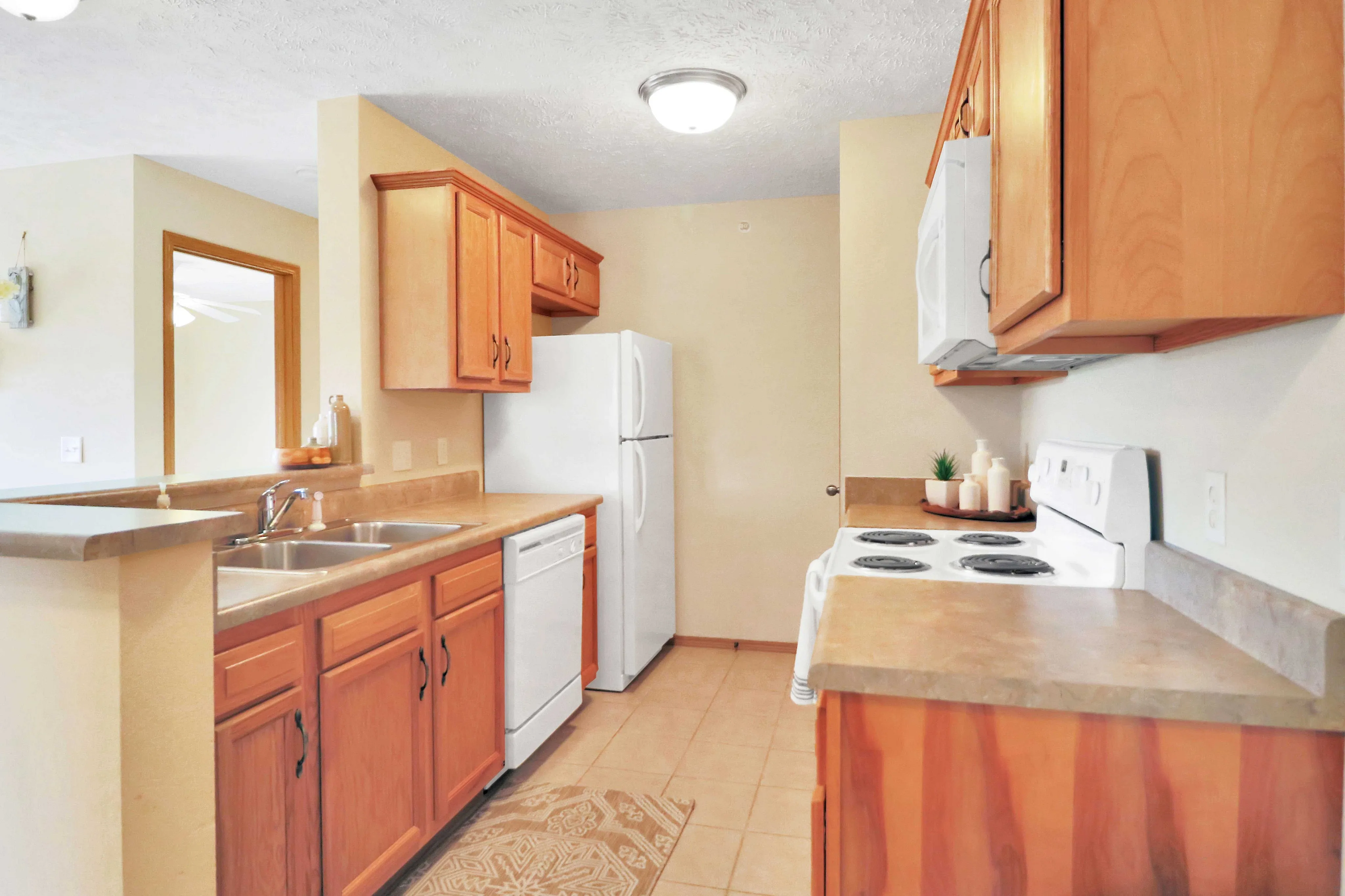 Inviting kitchen with warm wood cabinetry, modern appliances, and spacious countertops perfect for culinary creativity.