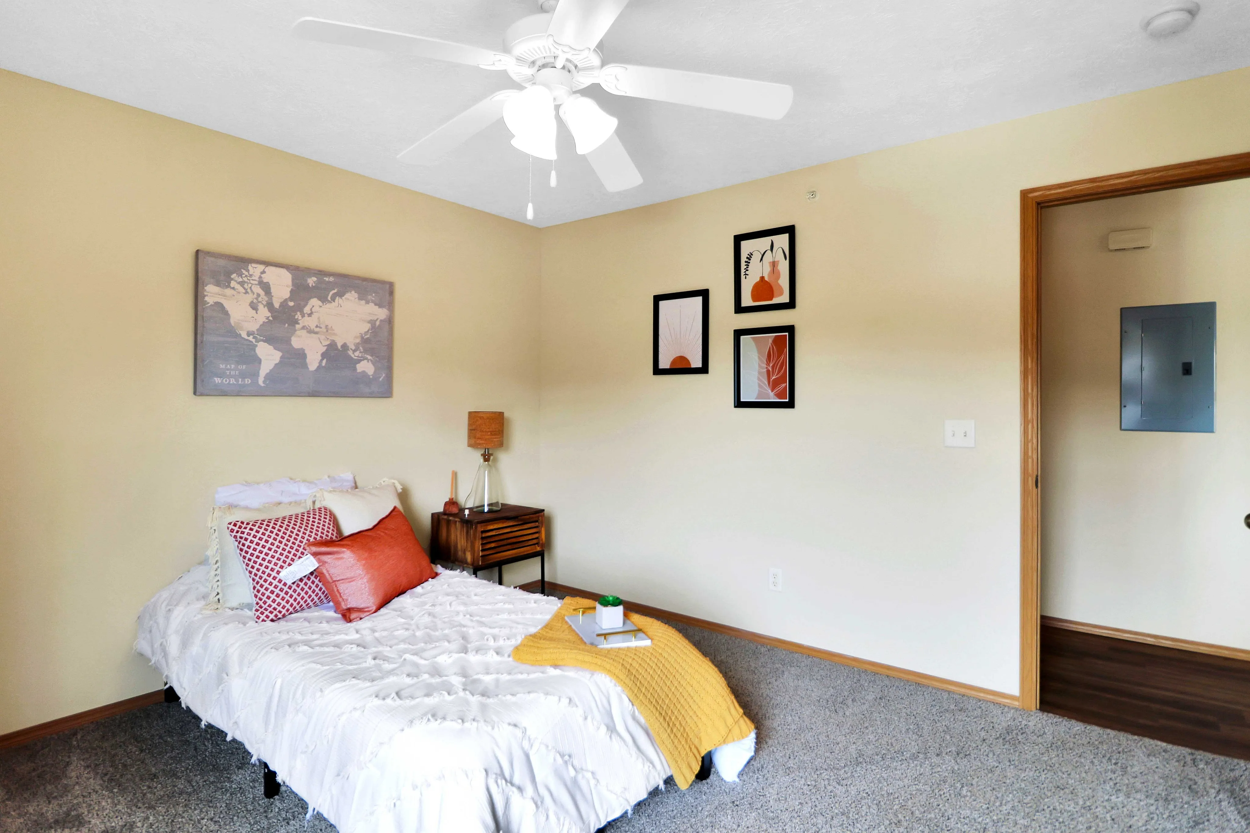 Cozy bedroom with stylish decor, featuring a plush bed with vibrant cushions, modern artwork, and a warm, inviting atmosphere.