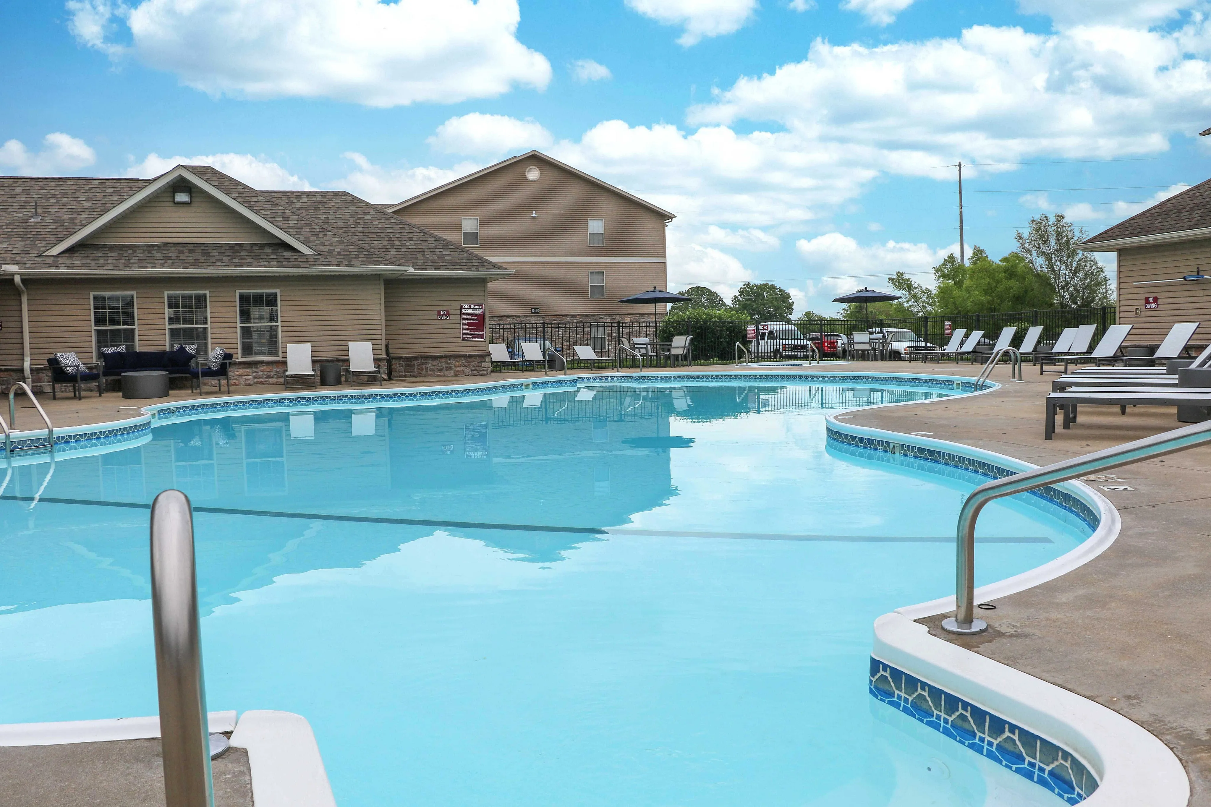 Inviting community pool area with comfortable lounge chairs and scenic views, perfect for relaxation and leisure.