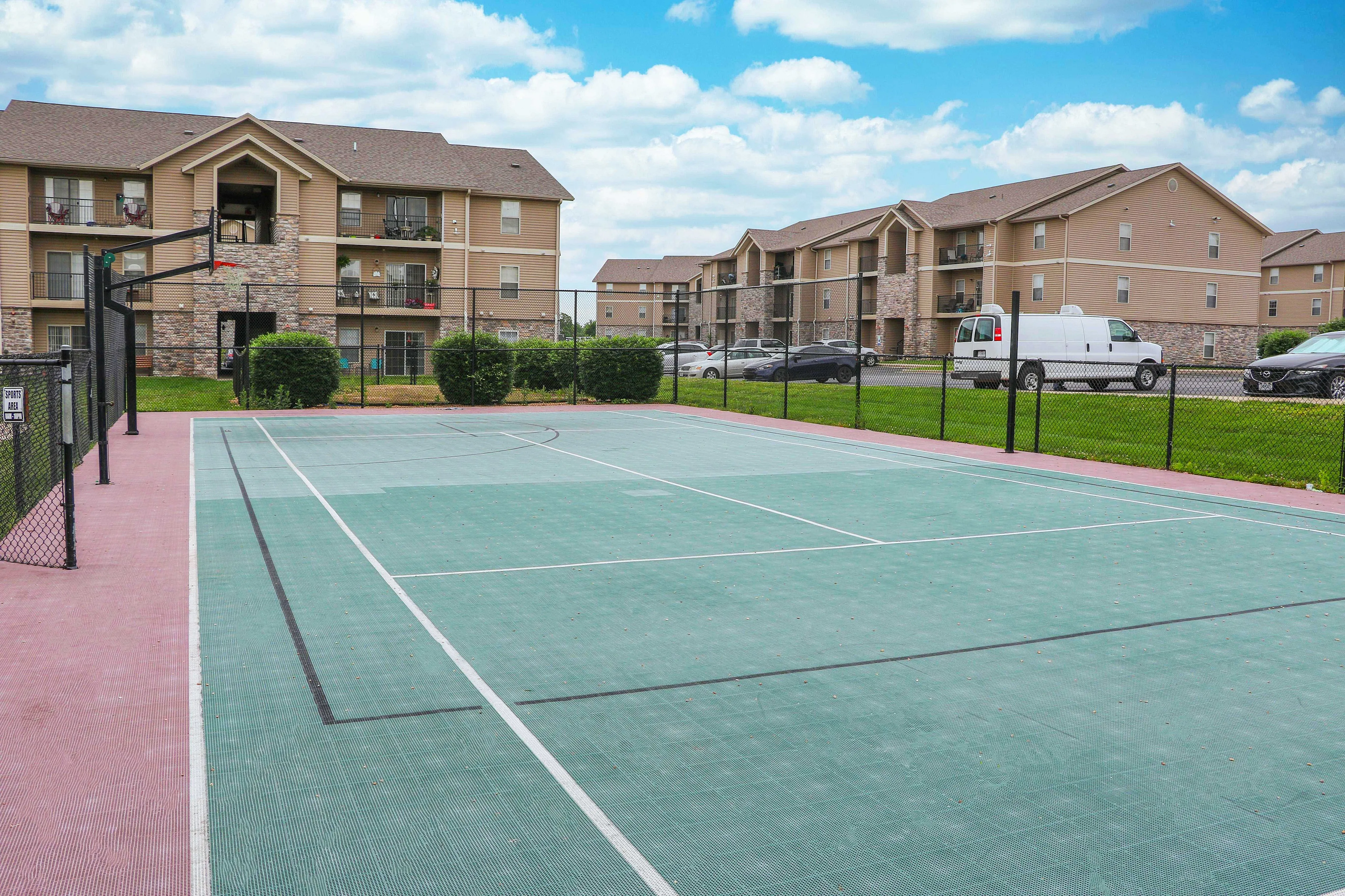 Inviting outdoor basketball court with modern apartment buildings in the background, offering a vibrant community lifestyle.