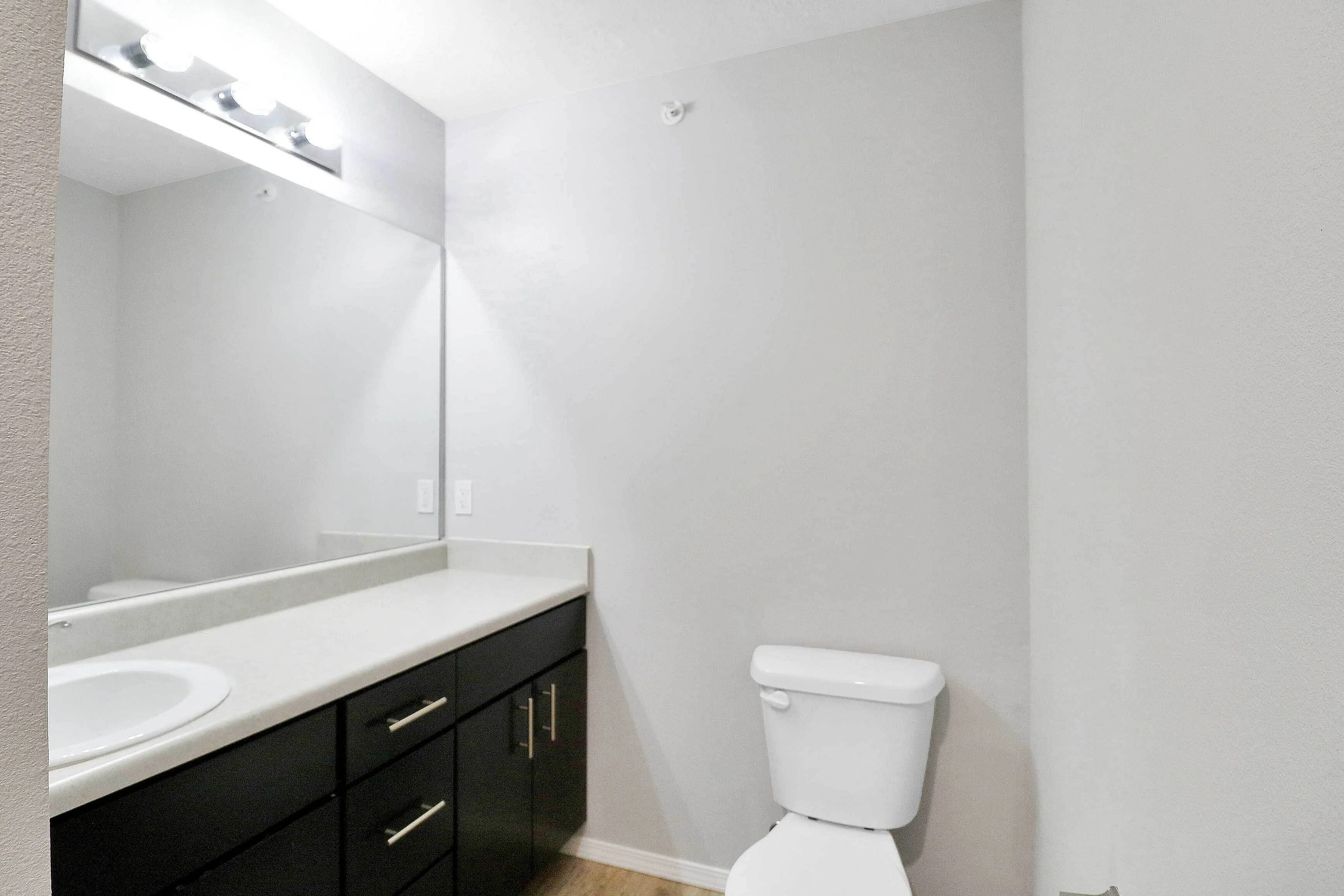 Bright and modern bathroom with sleek fixtures, large mirror, and ample countertop space.