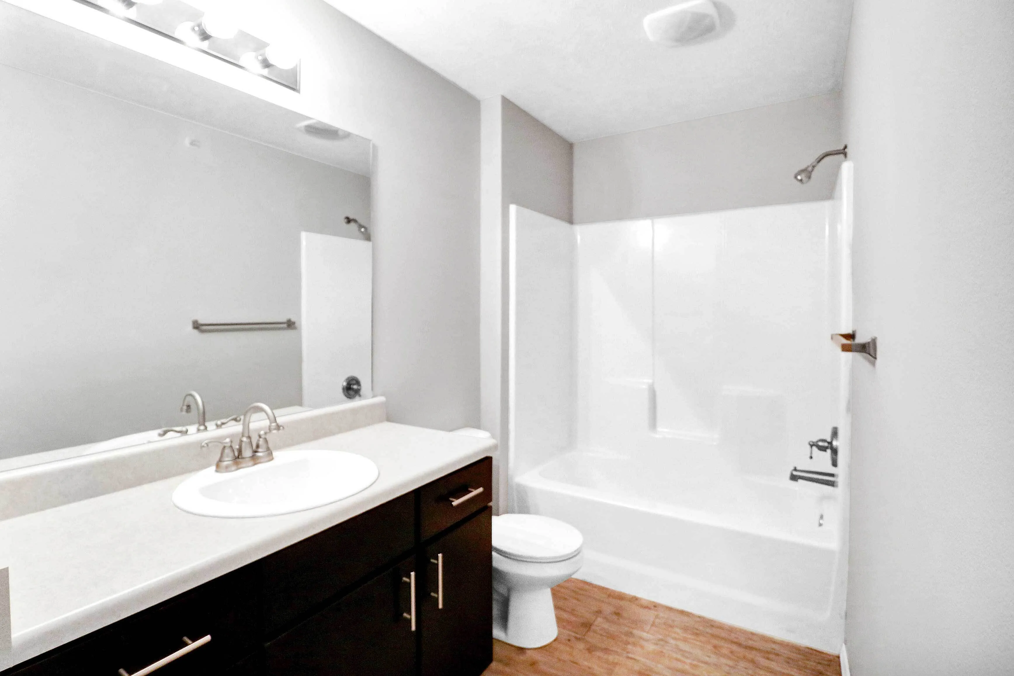 Elegant bathroom with modern fixtures, dark wood cabinetry, and a pristine white bathtub for a sophisticated touch.