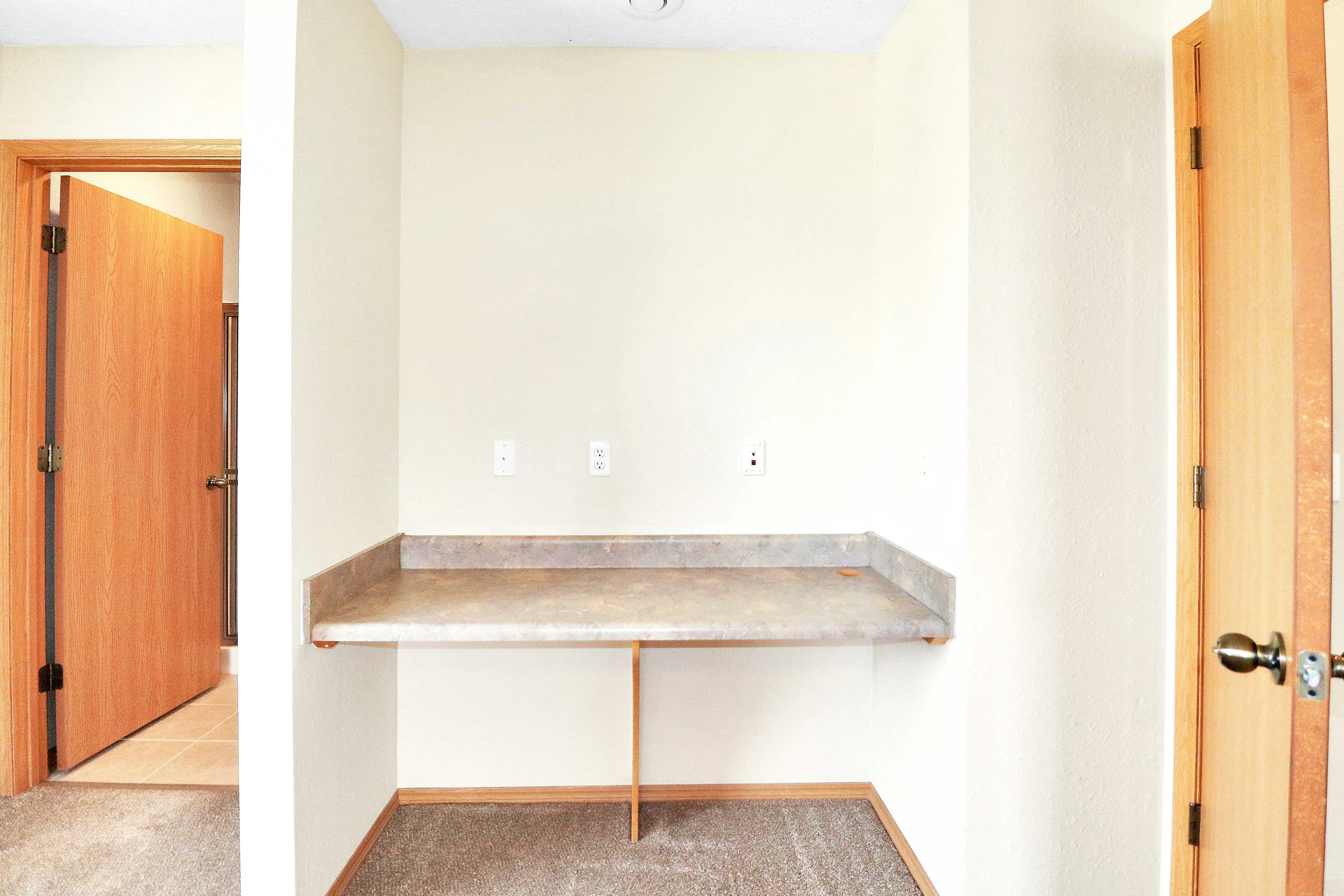 Bright and inviting alcove with built-in desk, perfect for a home office or study area, featuring natural wood accents and neutral tones.