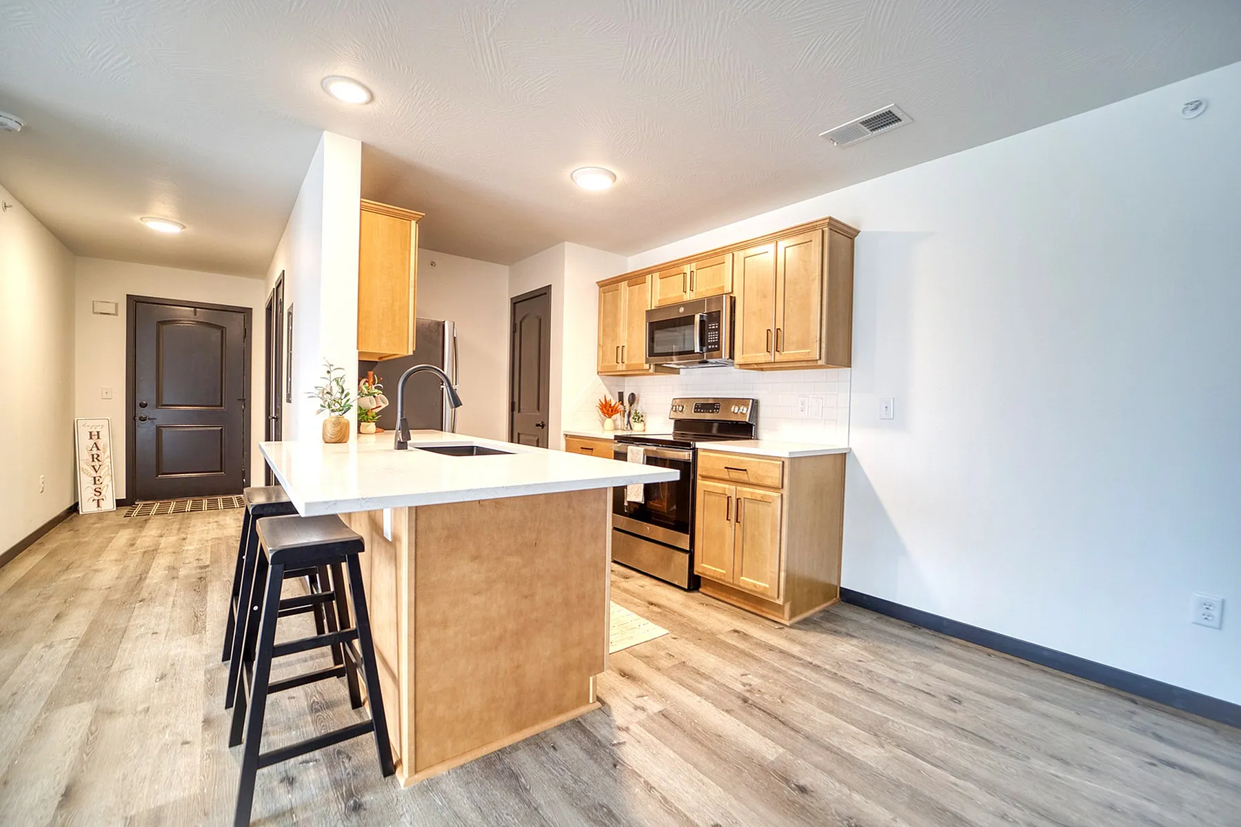 Modern kitchen with island seating, sleek appliances, and elegant wood cabinetry.