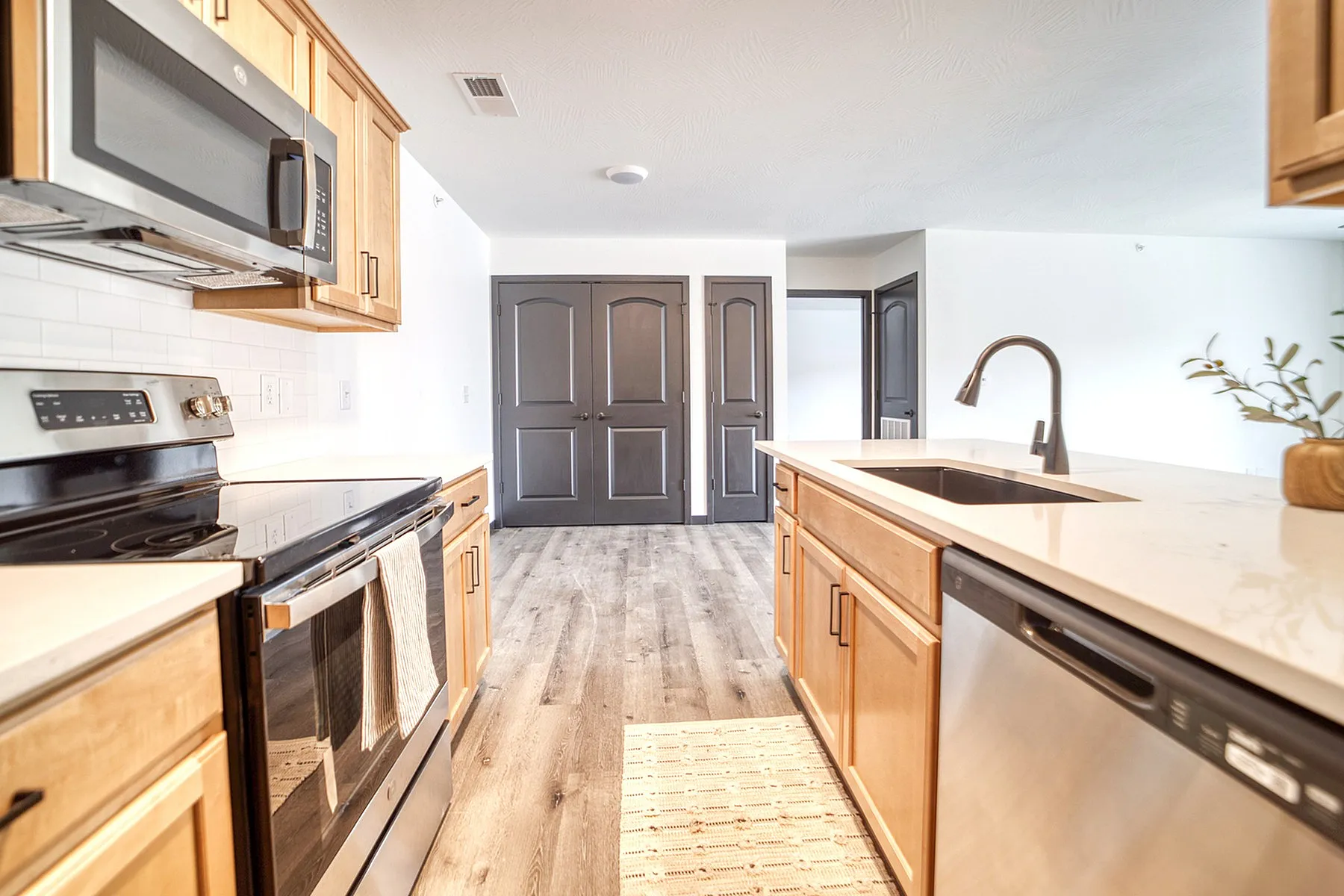 Contemporary kitchen with sleek stainless steel appliances, elegant wooden cabinetry, and a chic minimalist design.