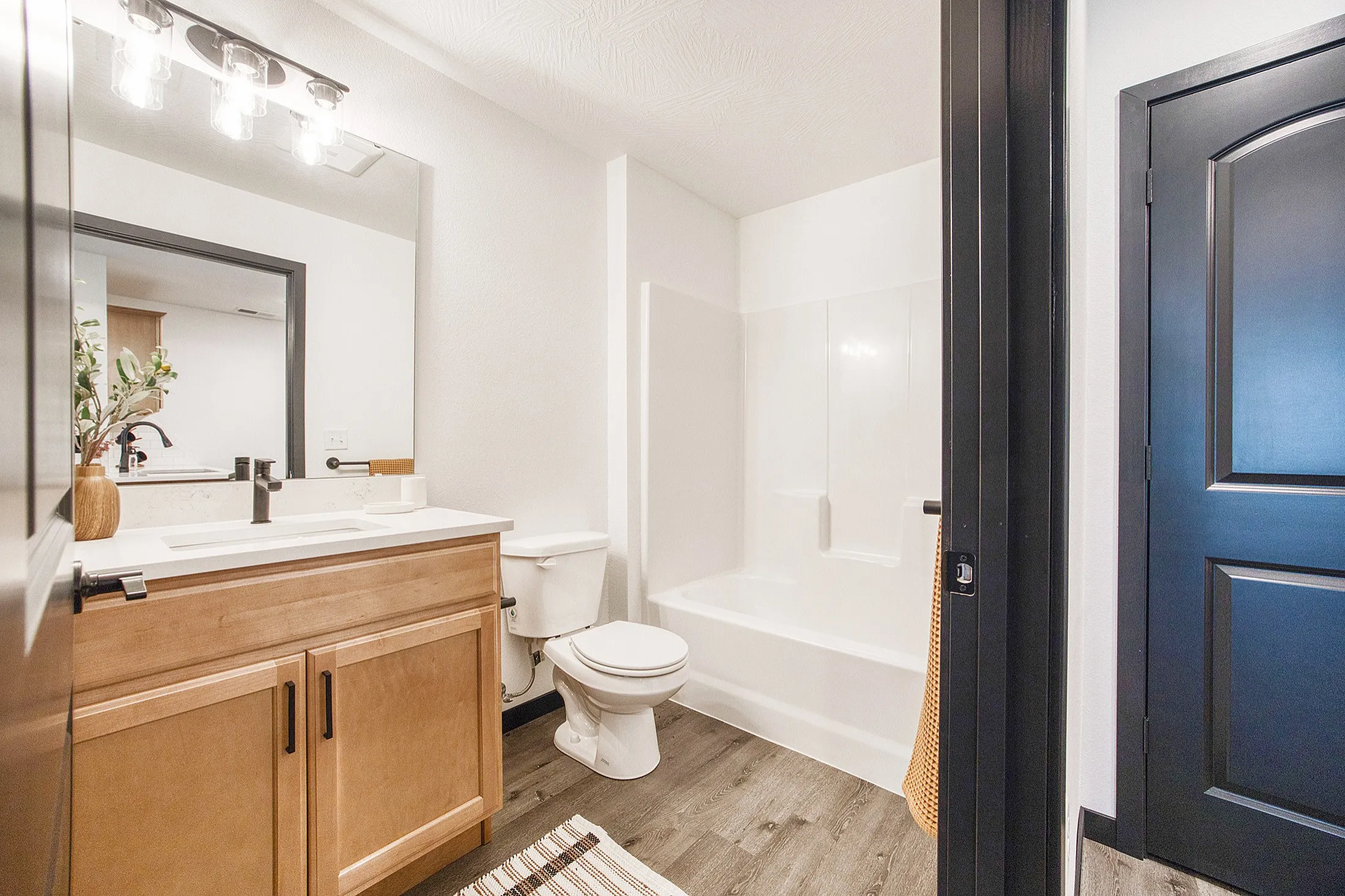 Modern bathroom featuring sleek fixtures, a spacious vanity, elegant lighting, and a pristine bathtub, offering a serene retreat.