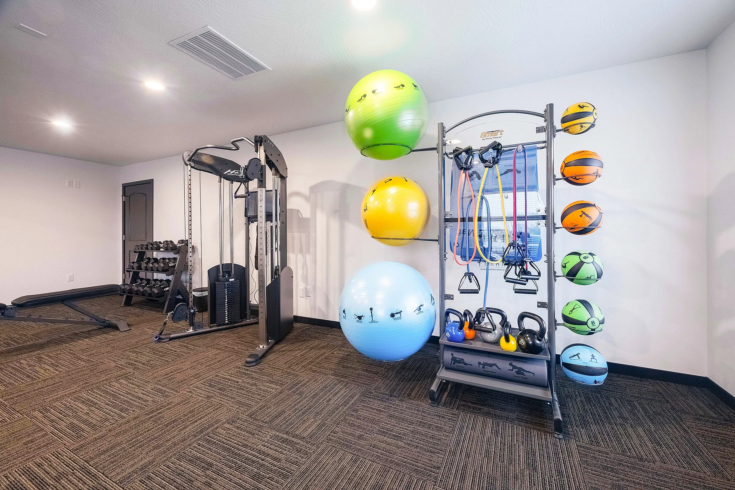 Modern fitness room with versatile gym equipment, vibrant exercise balls, and colorful kettlebells, perfect for an energizing workout.