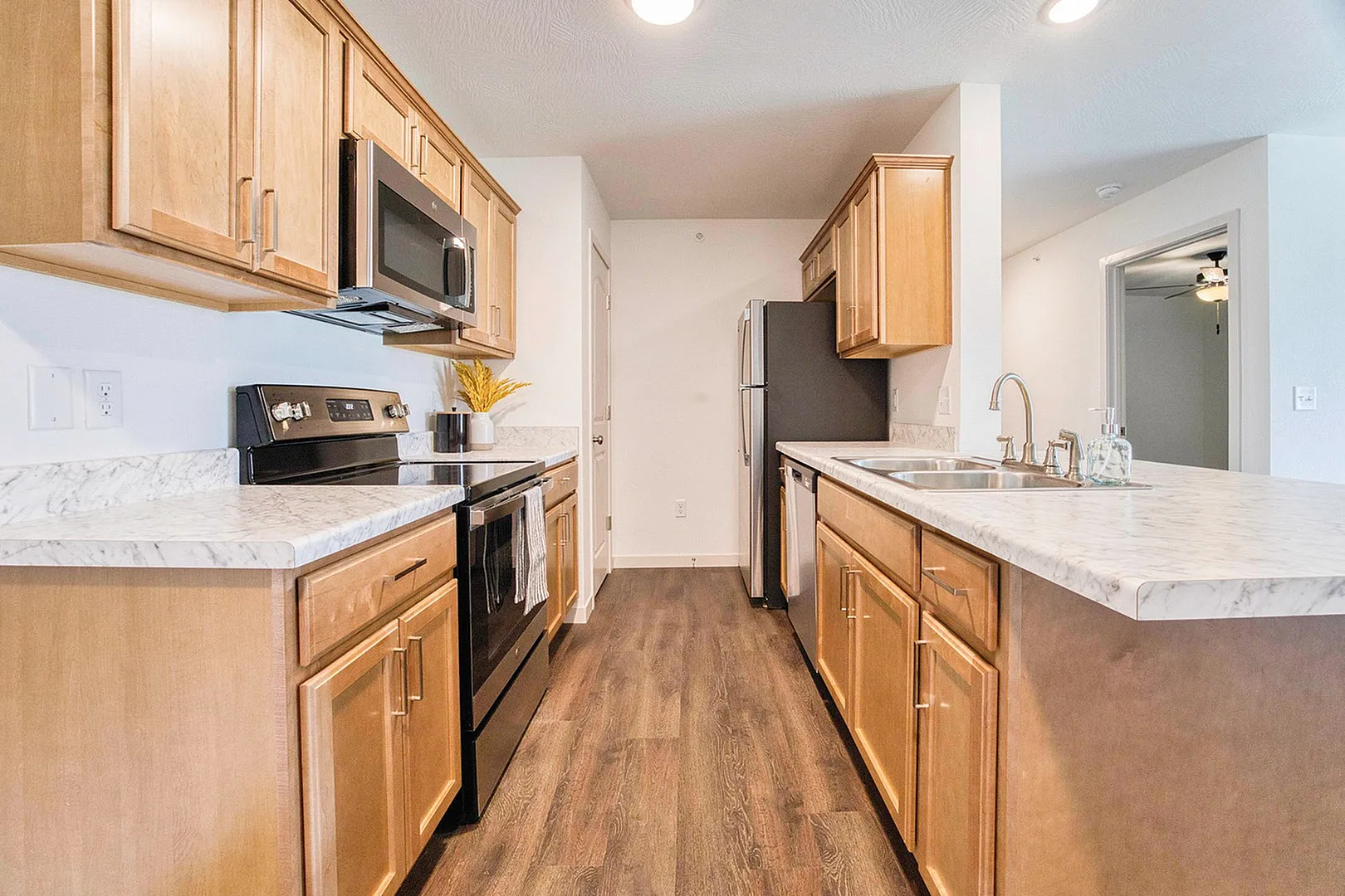 Modern kitchen with elegant wood cabinets, marble countertops, and stainless steel appliances, ideal for culinary creativity.