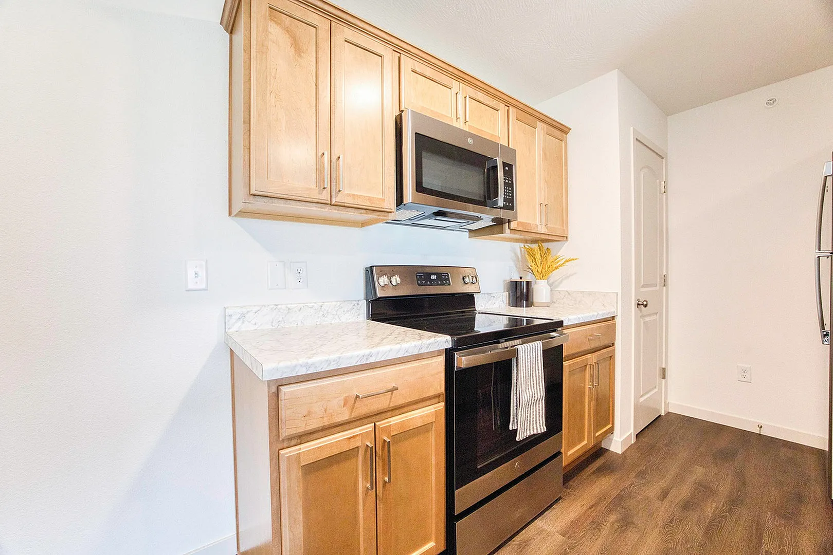 Modern kitchen with sleek appliances, wooden cabinets, and elegant marble countertops, creating a warm and inviting space.