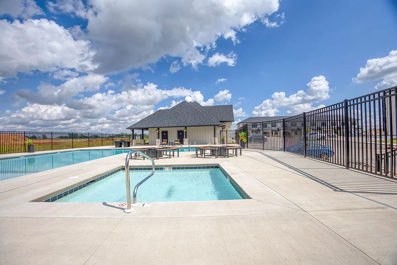Inviting outdoor pool area with clear blue water, set against a picturesque sky, providing a perfect space for relaxation and leisure.