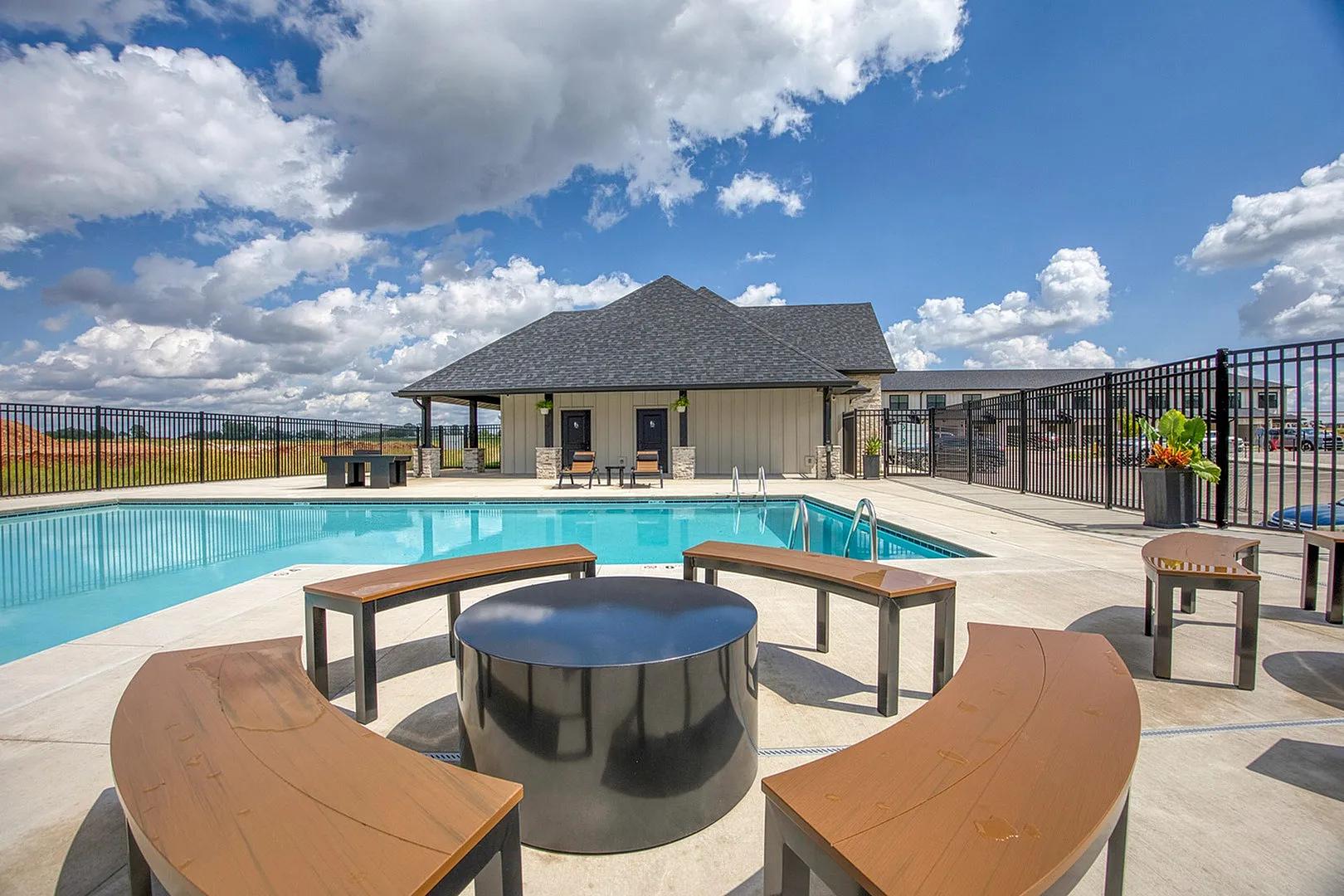 Inviting outdoor pool area with stylish seating and a breathtaking view of the sky, perfect for relaxation and hosting gatherings.