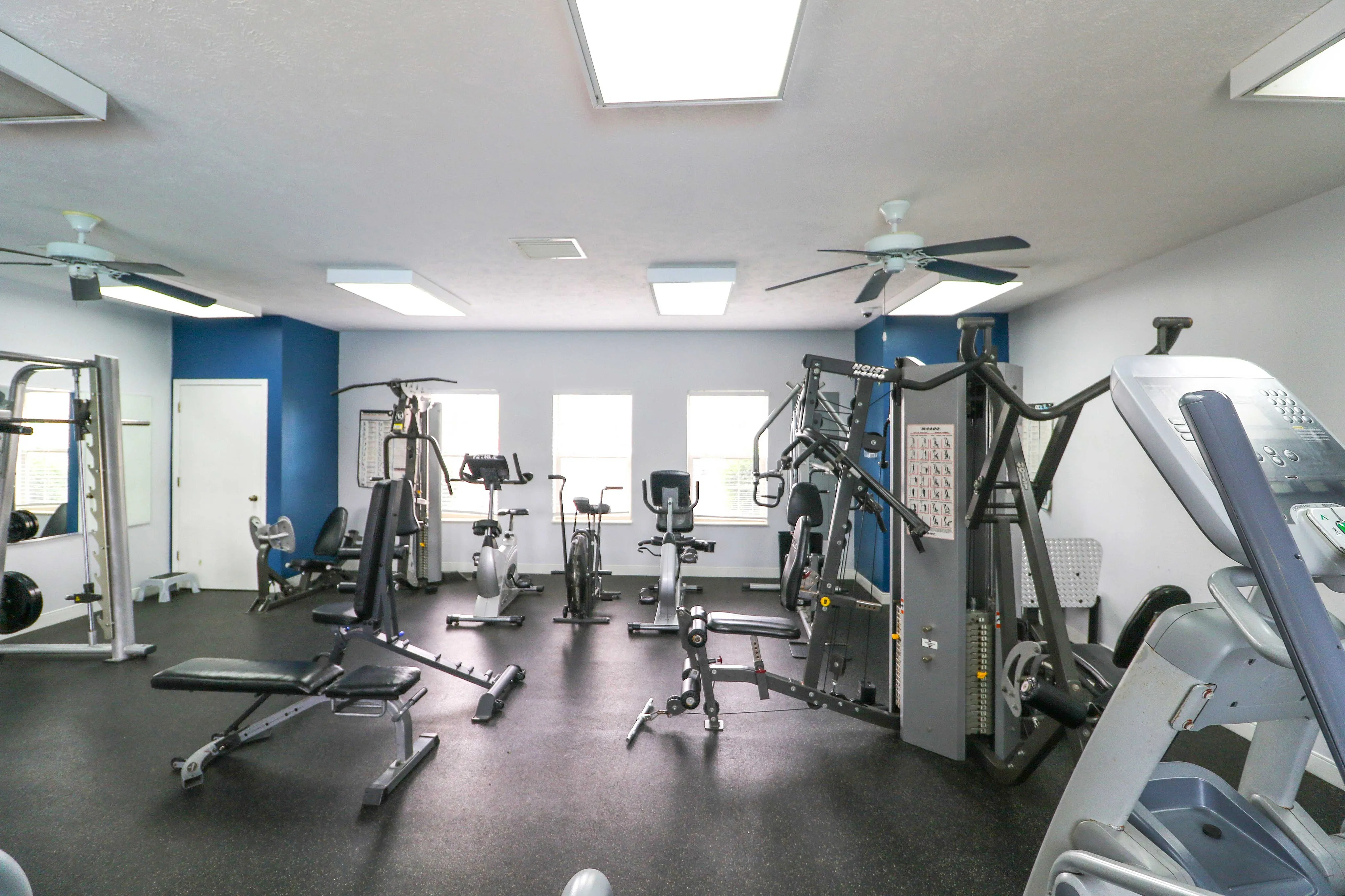 Modern fitness center equipped with state-of-the-art machines and bright natural lighting, perfect for an energizing workout.