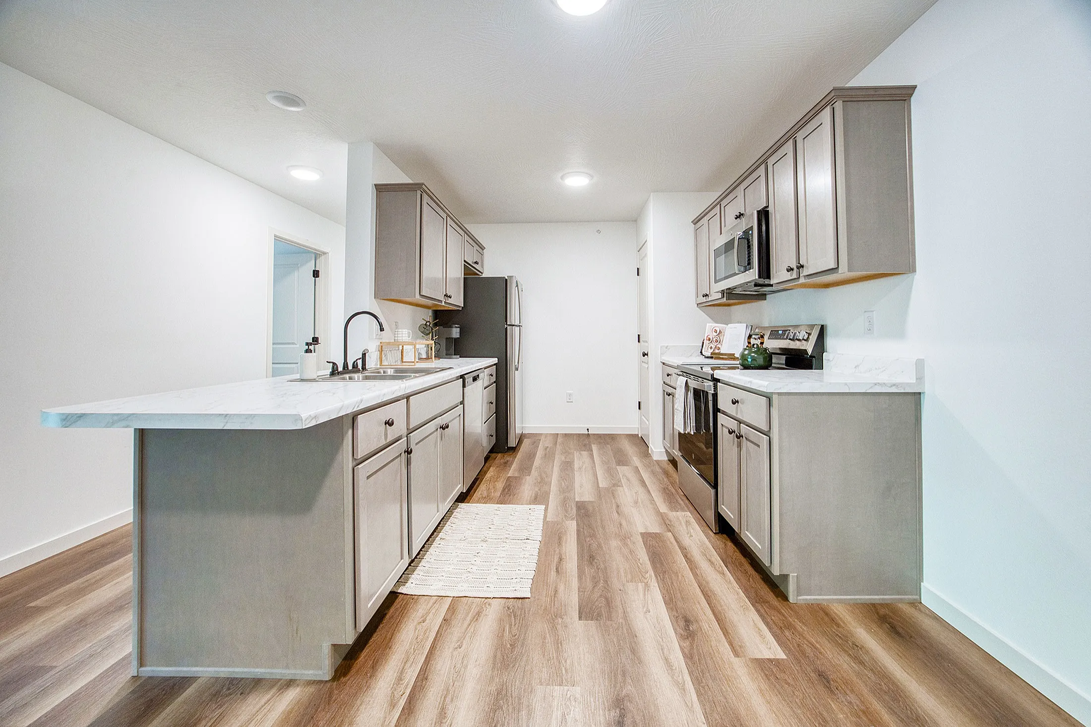 Modern kitchen with sleek cabinetry, spacious countertops, and stylish wooden flooring, perfect for culinary enthusiasts.
