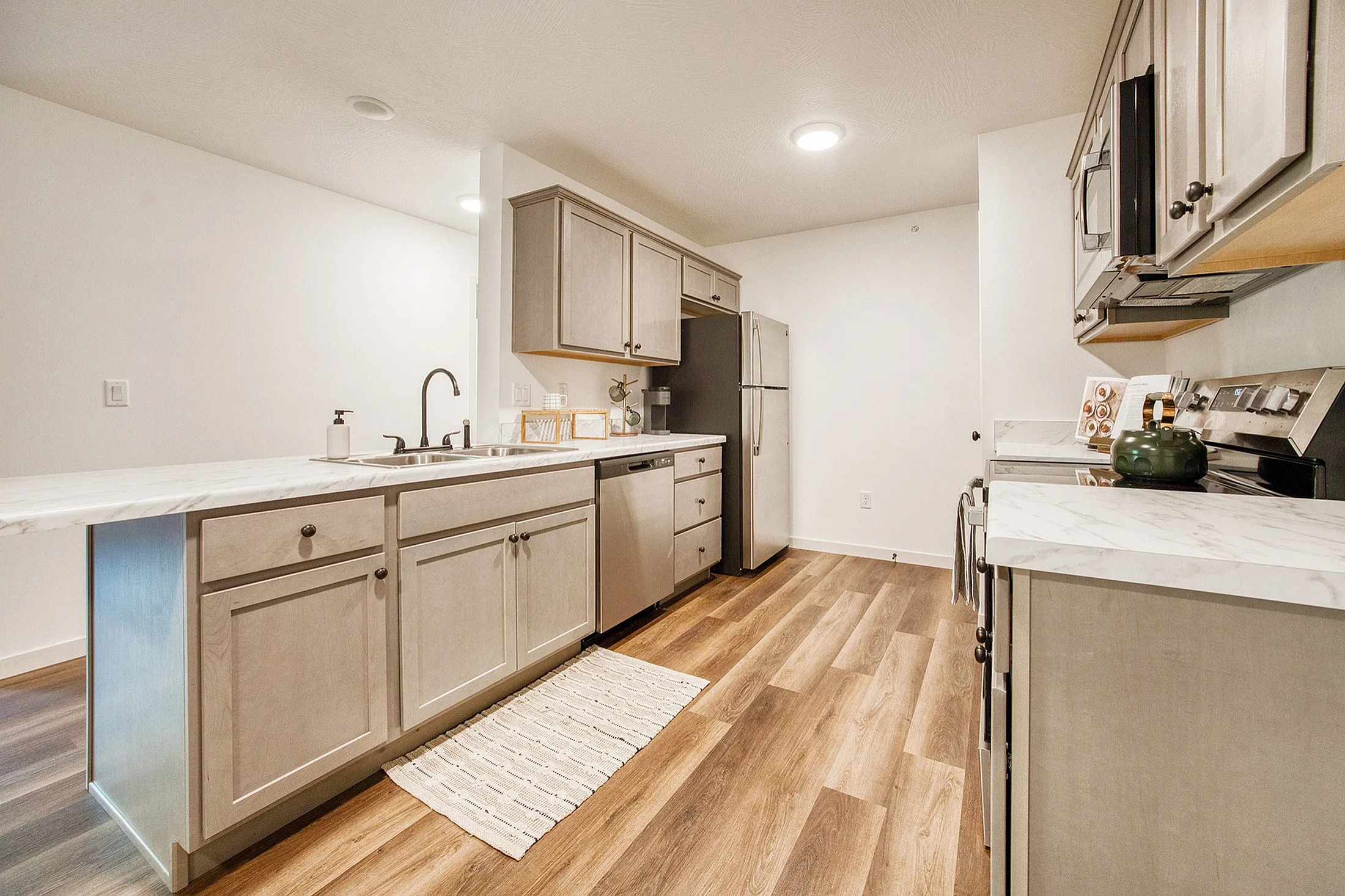 Modern kitchen with sleek stainless steel appliances, elegant wooden flooring, and stylish marble countertops.