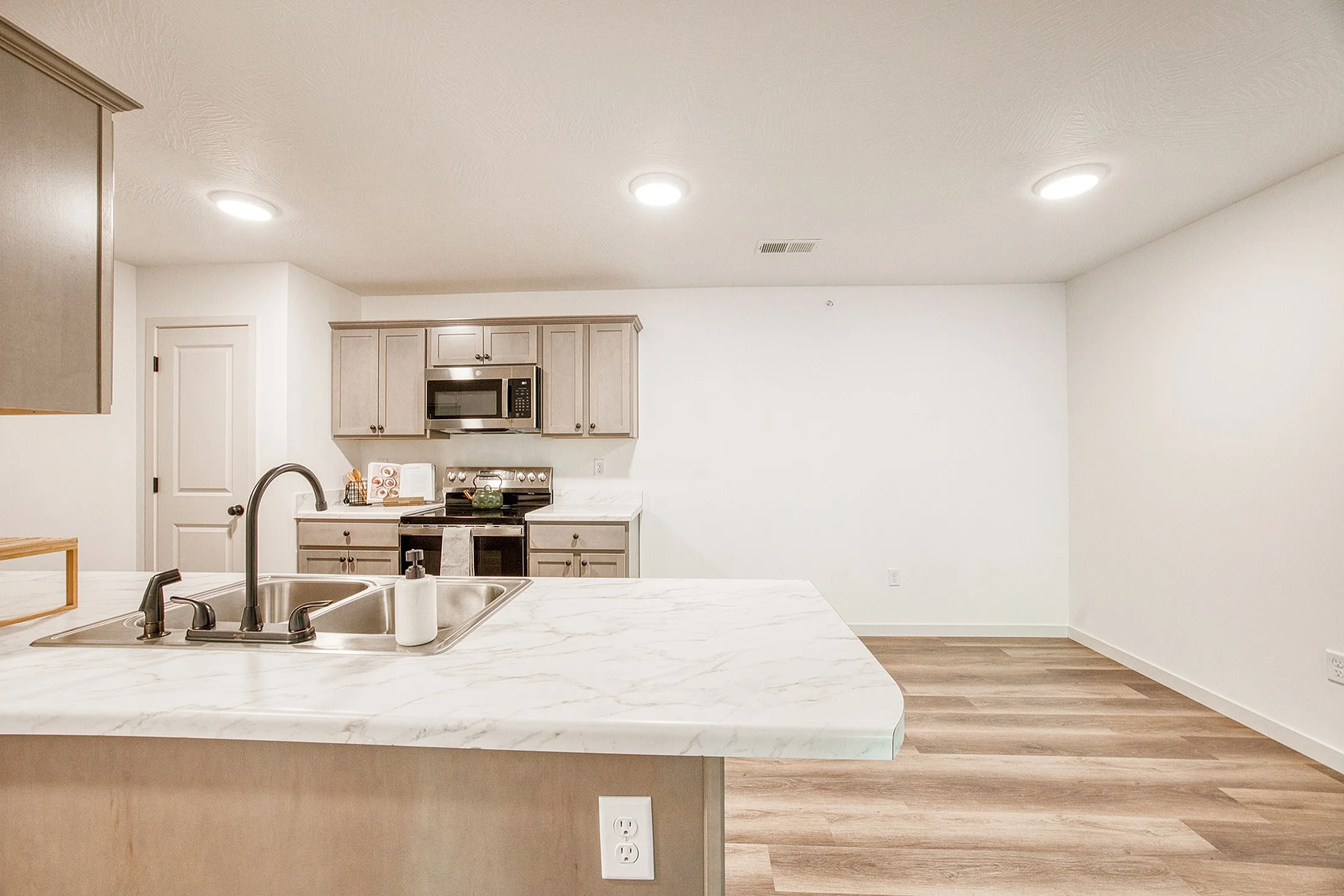 Modern kitchen with elegant marble countertop, stylish cabinetry, and stainless steel appliances in an airy, open-concept design.