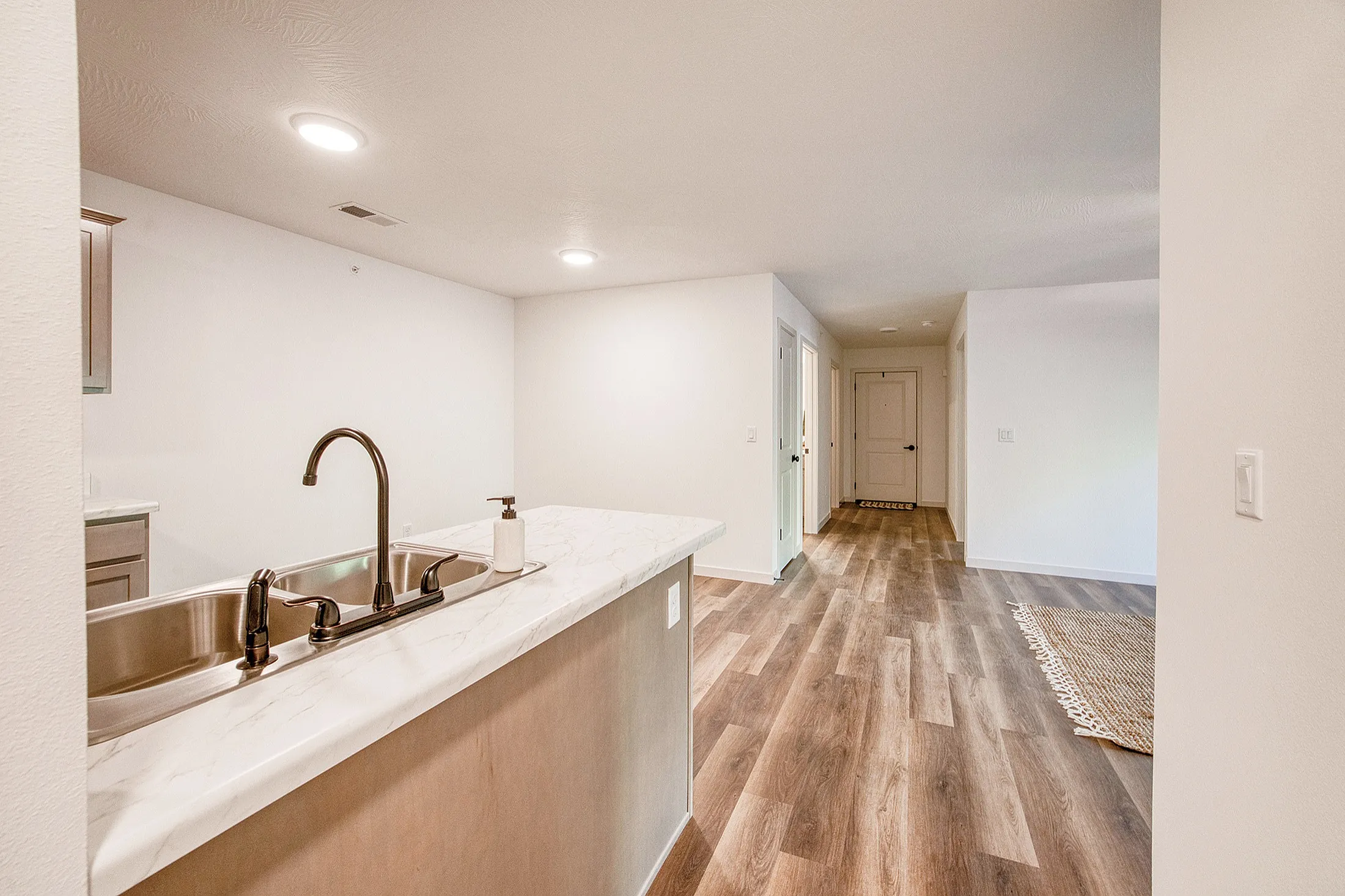 Inviting apartment interior featuring a modern kitchen with marble countertops and elegant wood flooring throughout.