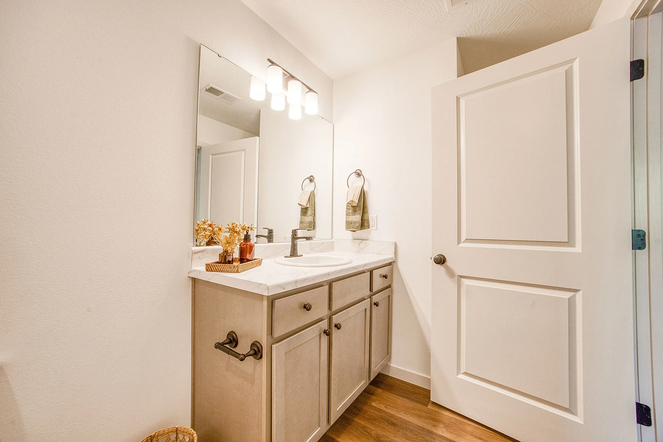 Modern bathroom with elegant vanity, marble countertop, soft lighting, and stylish decor.