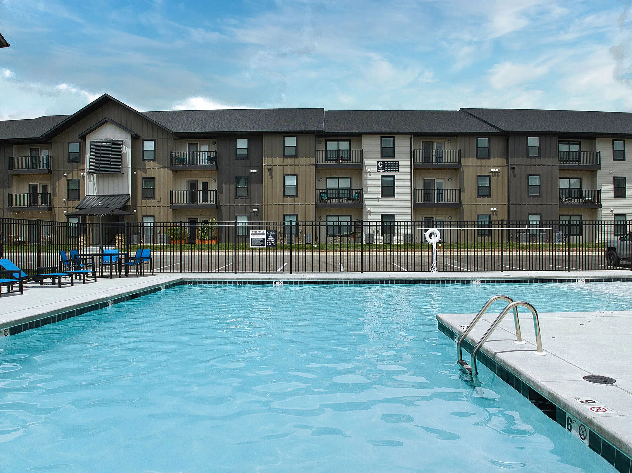 Inviting apartment complex with modern exterior and refreshing swimming pool, perfect for relaxation and leisure.