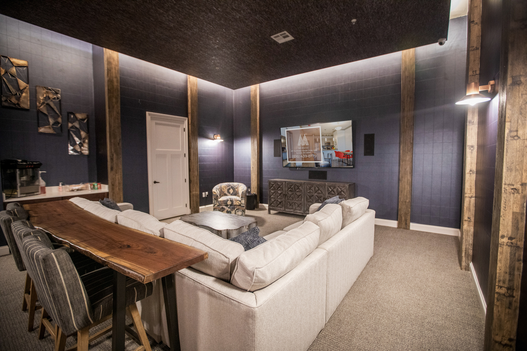 Luxurious home media room with plush seating, sleek wood accents, and a large flat-screen TV for ultimate relaxation.