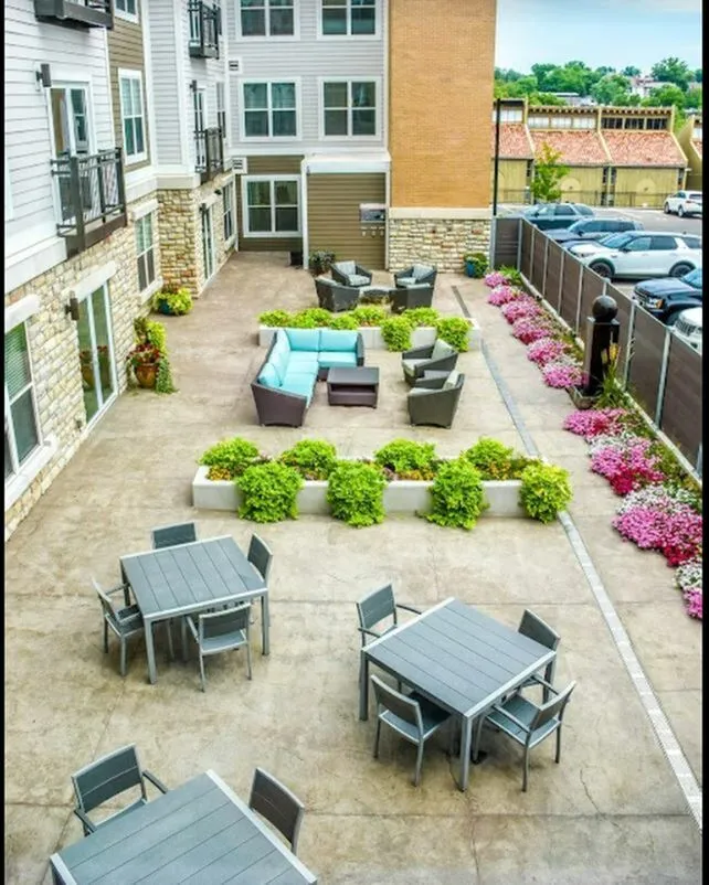 Charming outdoor patio with cozy seating areas, vibrant flower beds, and modern decor for a perfect relaxation spot.
