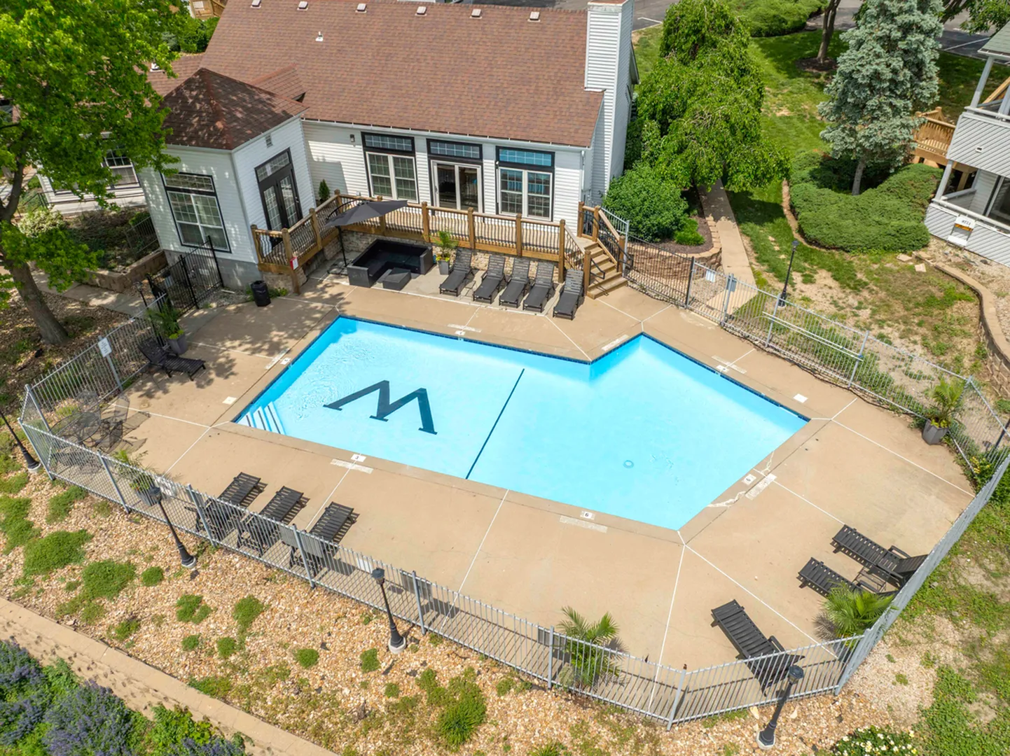 Inviting pool area with sunny lounge chairs and lush greenery, perfect for relaxation and leisure.
