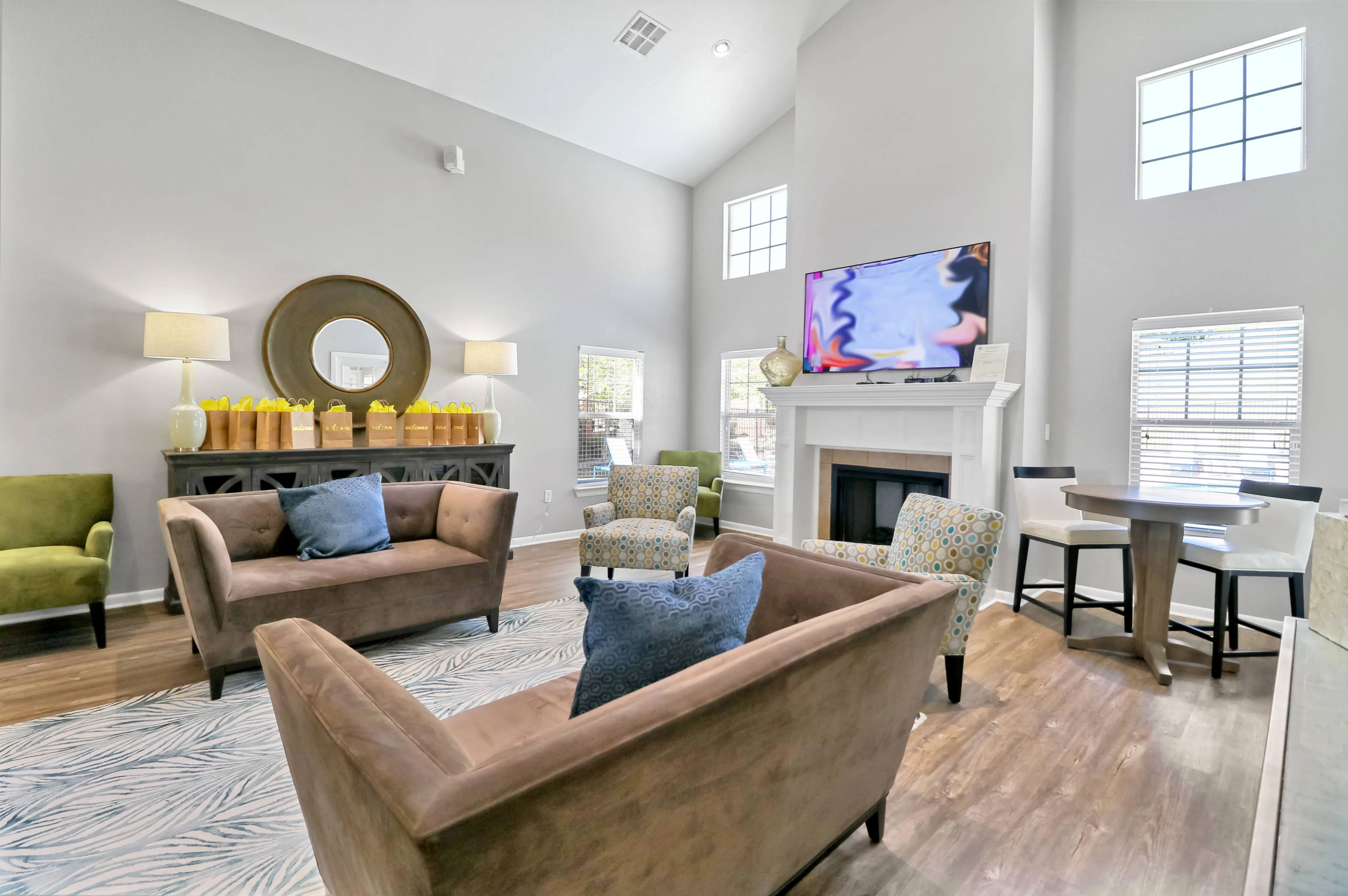 Inviting living room with high ceilings, modern d&eacute;cor, cozy seating, and abundant natural light.