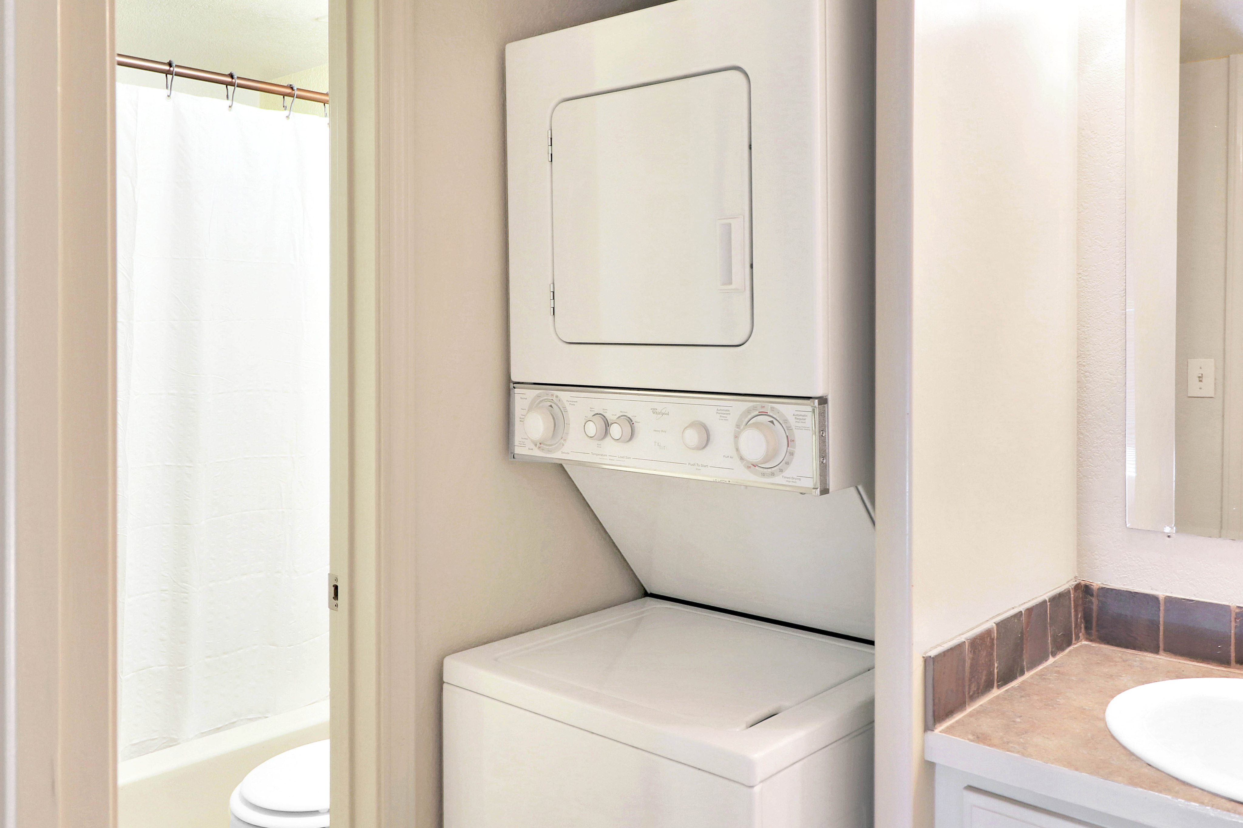 Convenient in-unit laundry tucked neatly beside a pristine bathroom for modern living.