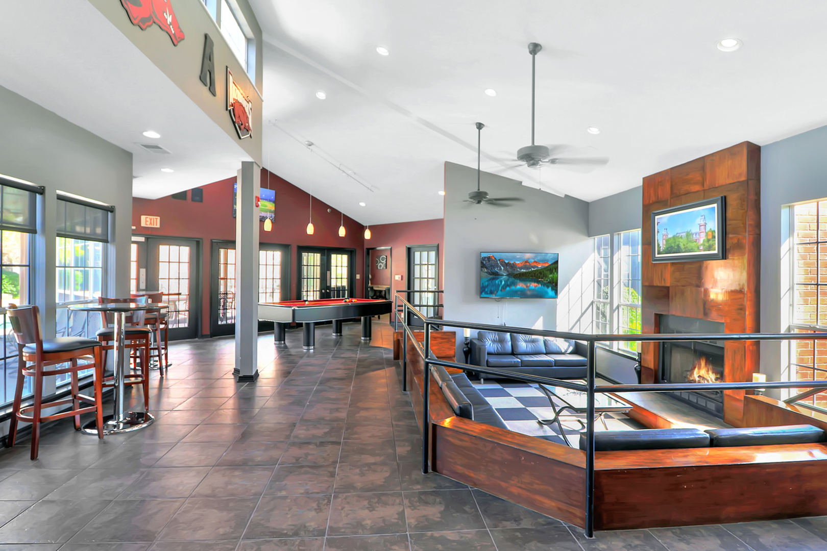 Bright and modern recreation room featuring a pool table, stylish seating area, and cozy fireplace, perfect for relaxation and entertainment.