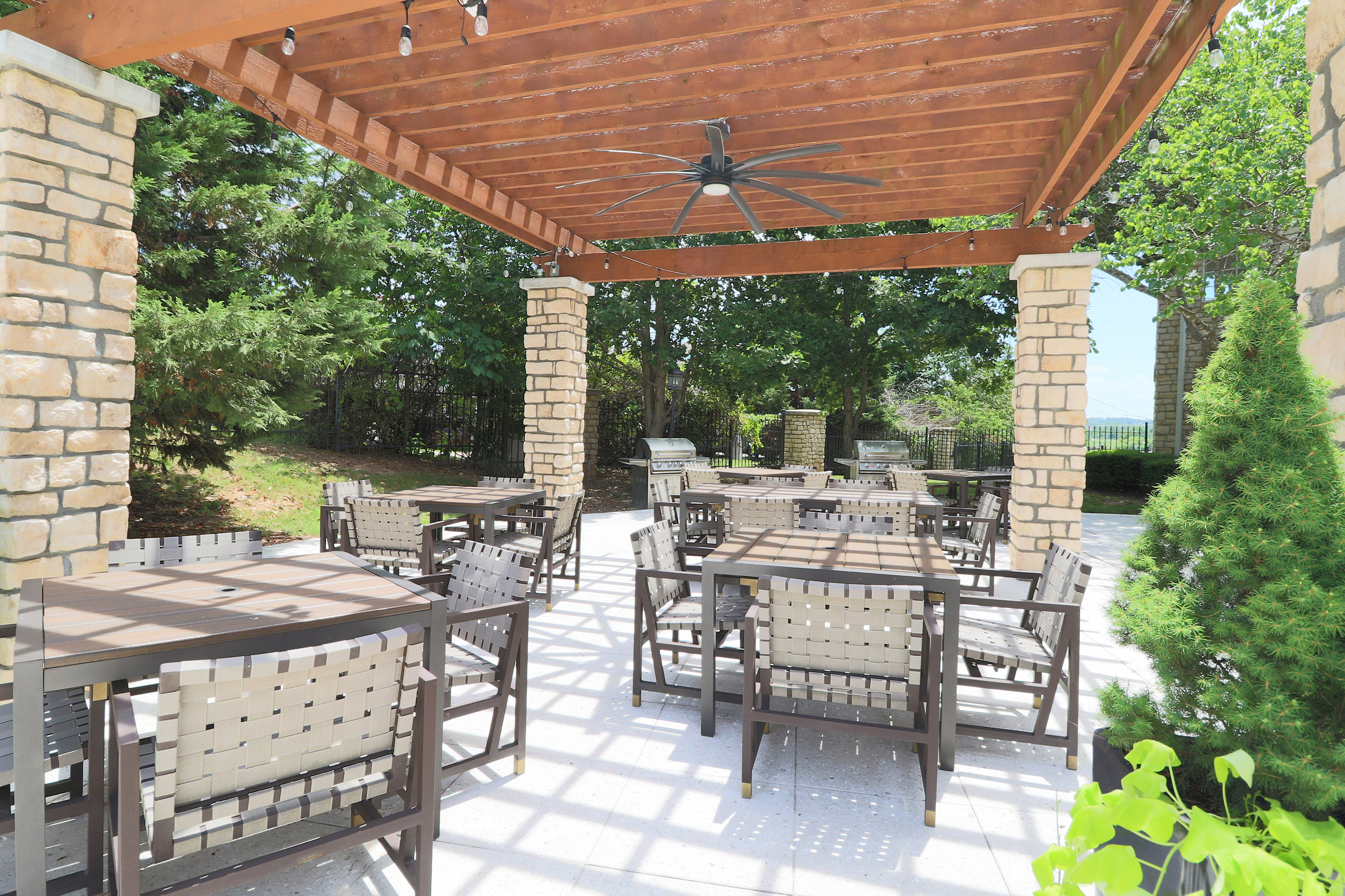 Beautiful outdoor patio with stylish wooden pergola, modern seating, and lush greenery, perfect for al fresco dining and relaxation.