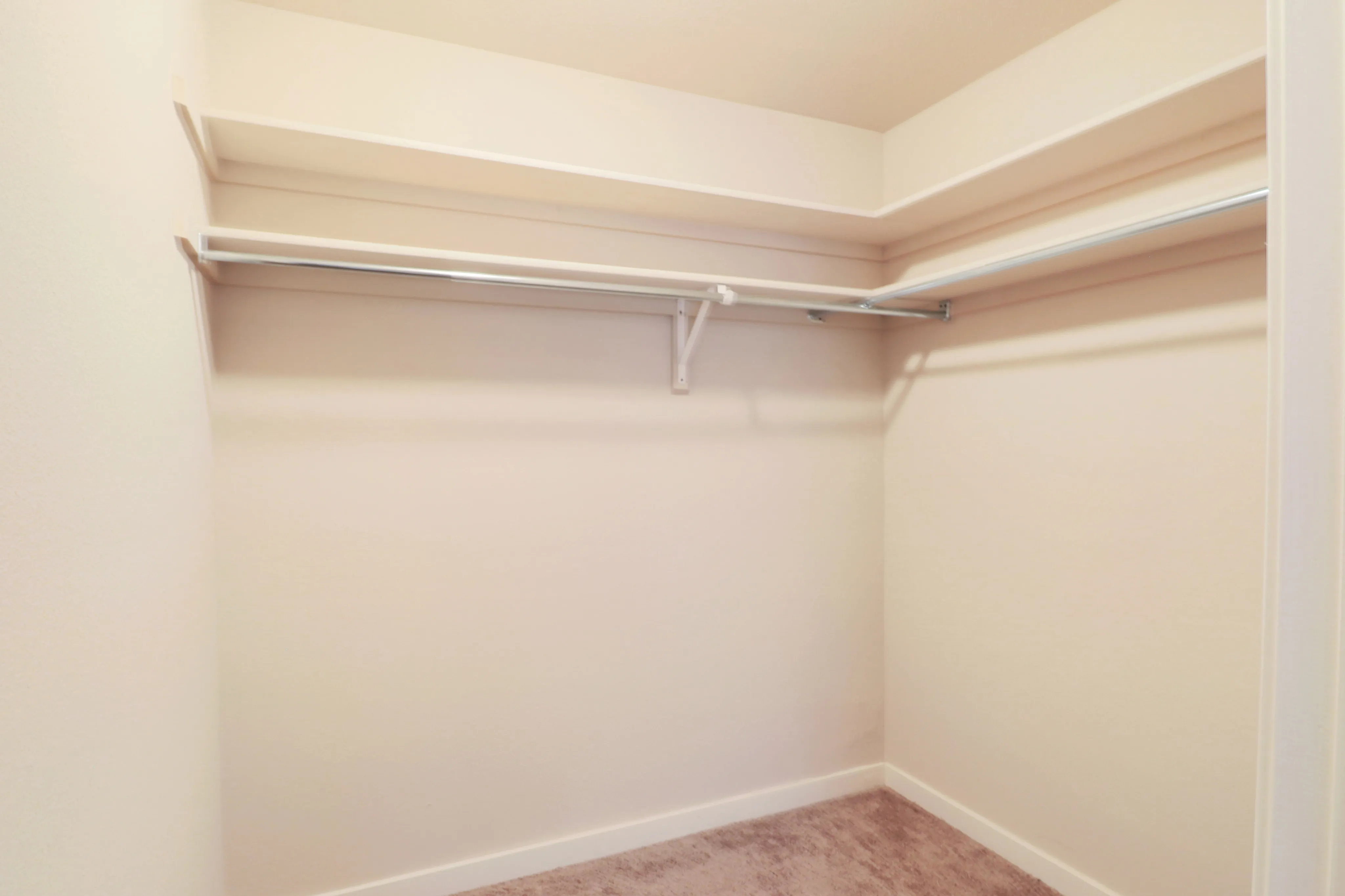 Spacious walk-in closet with ample shelving and hanging space, perfect for organized living and storage.