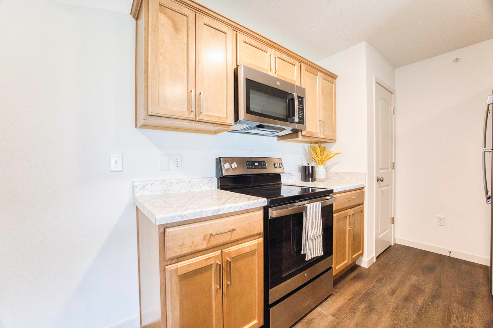 Modern kitchen with elegant wooden cabinets, stainless steel appliances, and marble countertops offering a sleek and inviting cooking space.