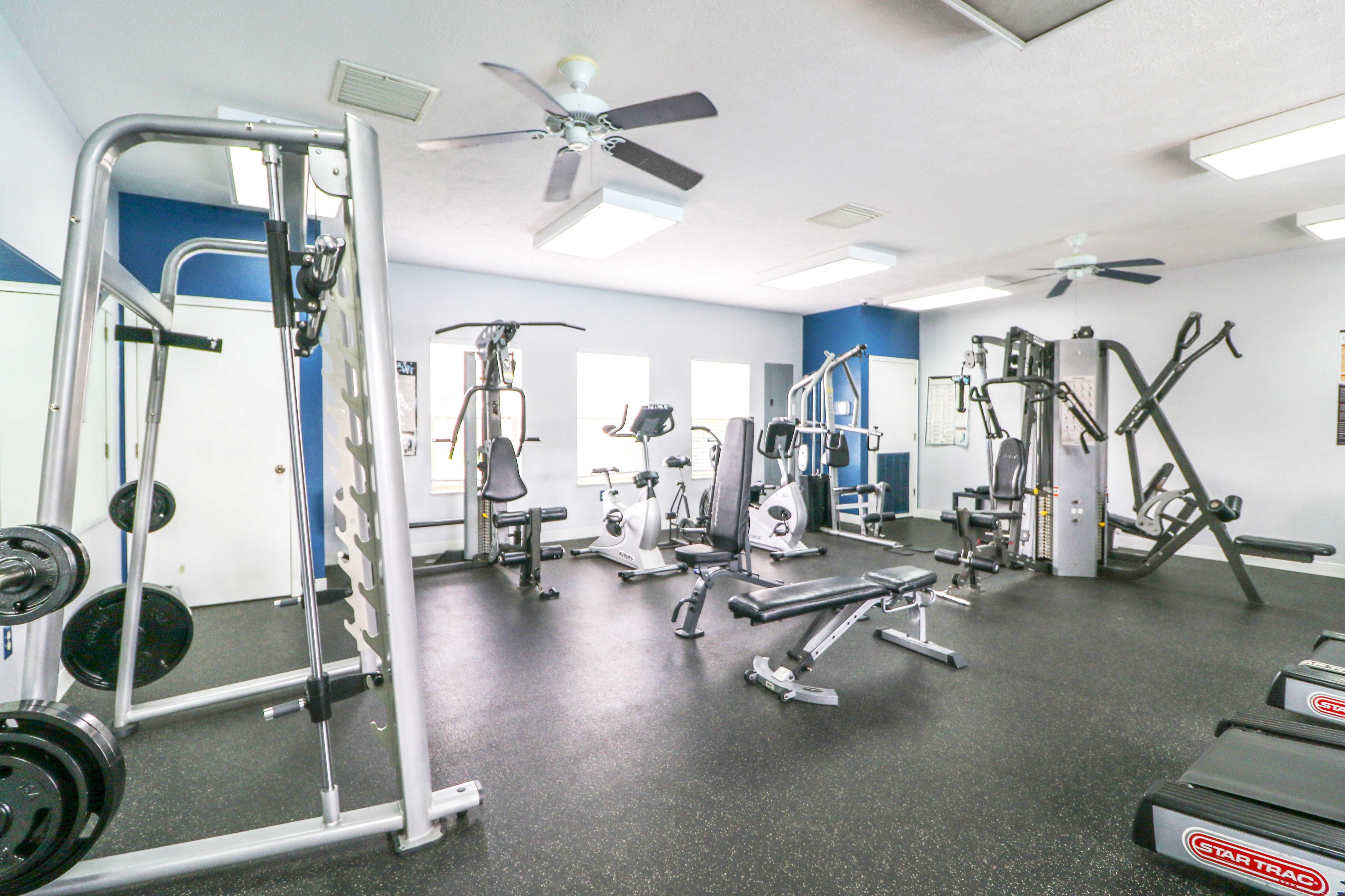 Modern fitness center with state-of-the-art gym equipment, including weight machines and cardio gear in a bright, spacious room.