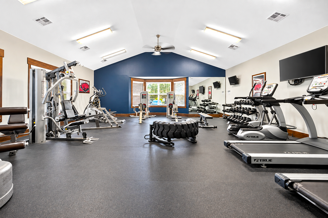 Spacious and modern fitness center with state-of-the-art gym equipment, including treadmills, weights, and strength machines, perfect for an invigorating workout.
