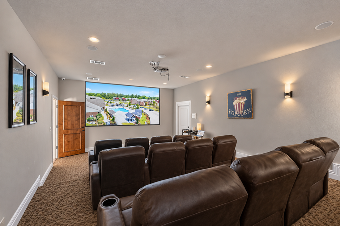 Luxurious home theater featuring plush leather seating and a large screen, perfect for an immersive viewing experience.