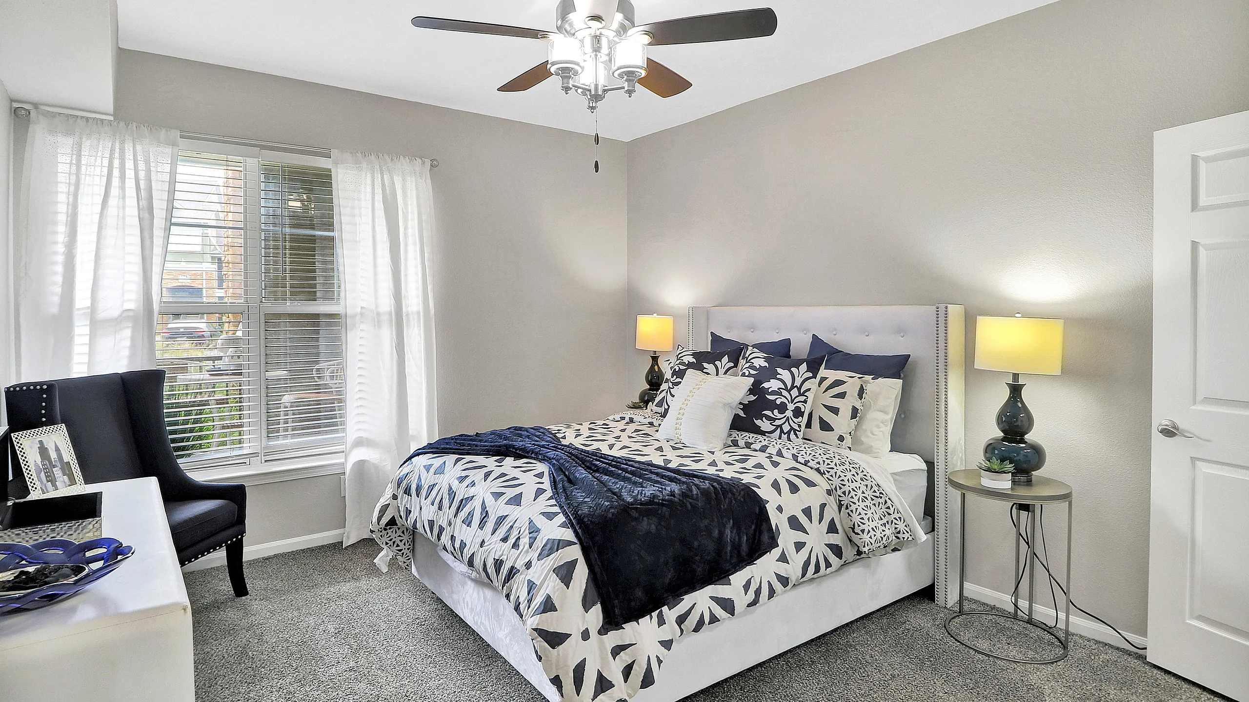 Bright and inviting bedroom featuring a plush bed, elegant decor, and ample natural light streaming through large windows.