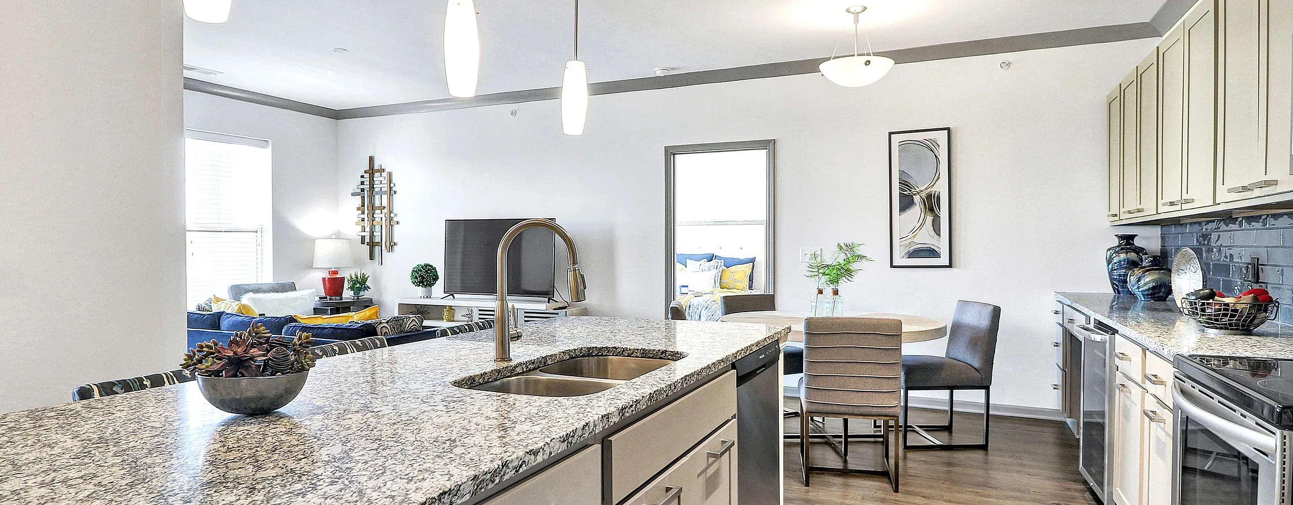 Contemporary open-plan apartment featuring a sleek kitchen with granite countertops, spacious dining area, and stylish living room accents.