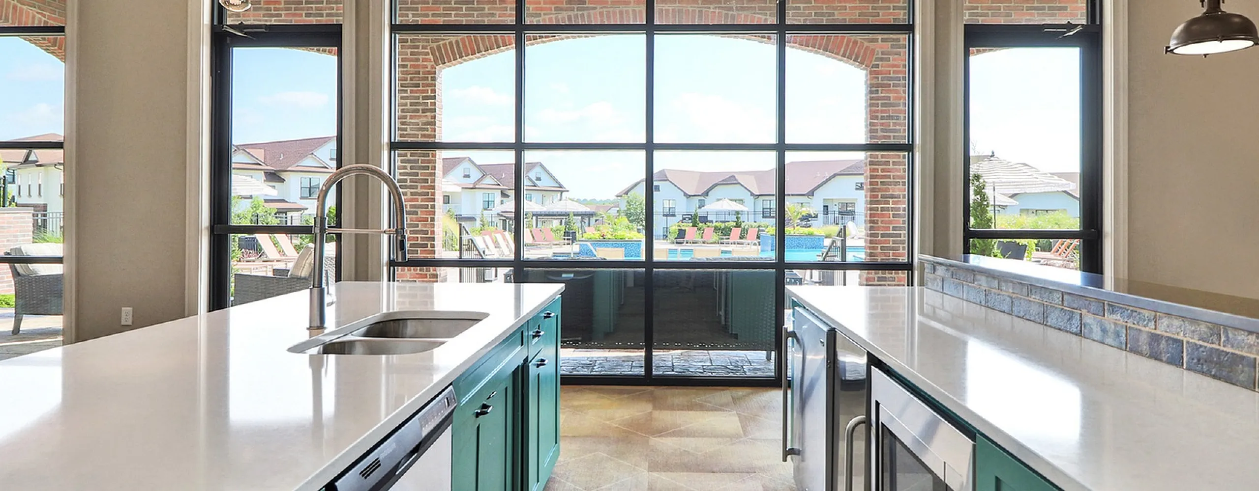 Chic modern kitchen with elegant island and floor-to-ceiling windows showcasing a stunning patio view.