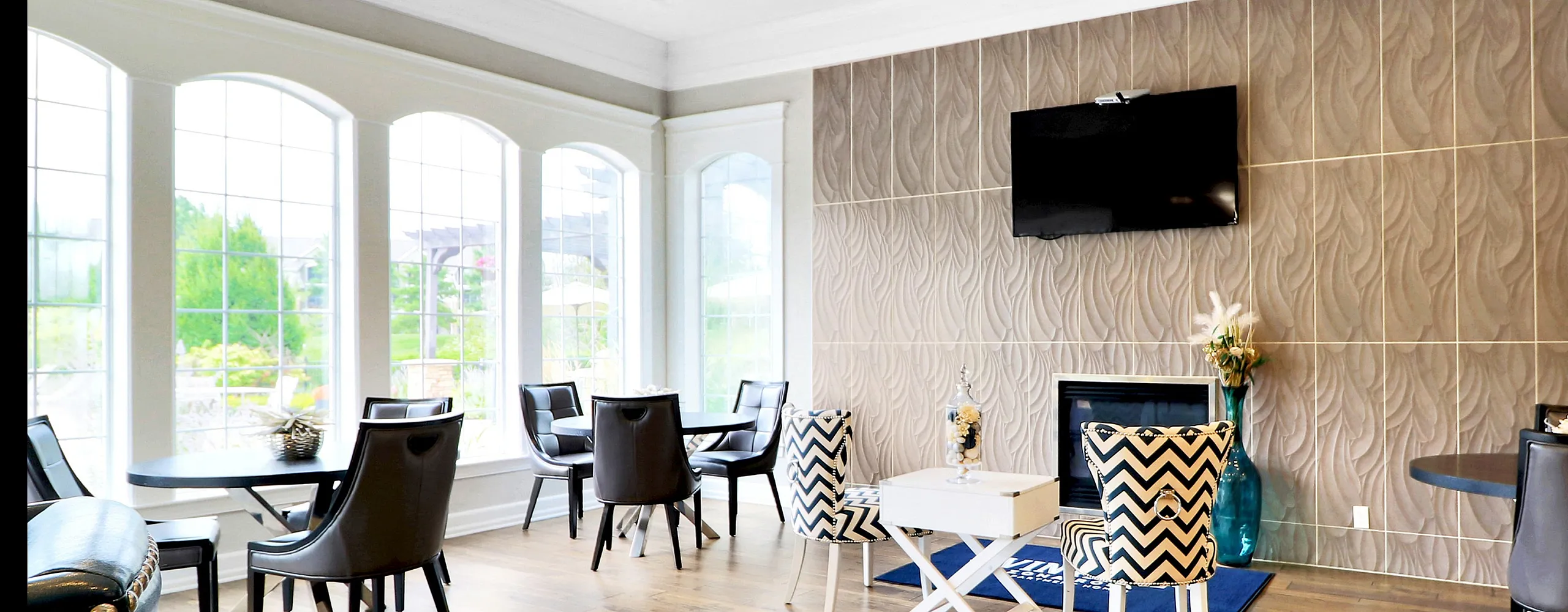 Elegant lounge area with modern decor, featuring large sunlit windows and stylish furnishings, perfect for relaxation.