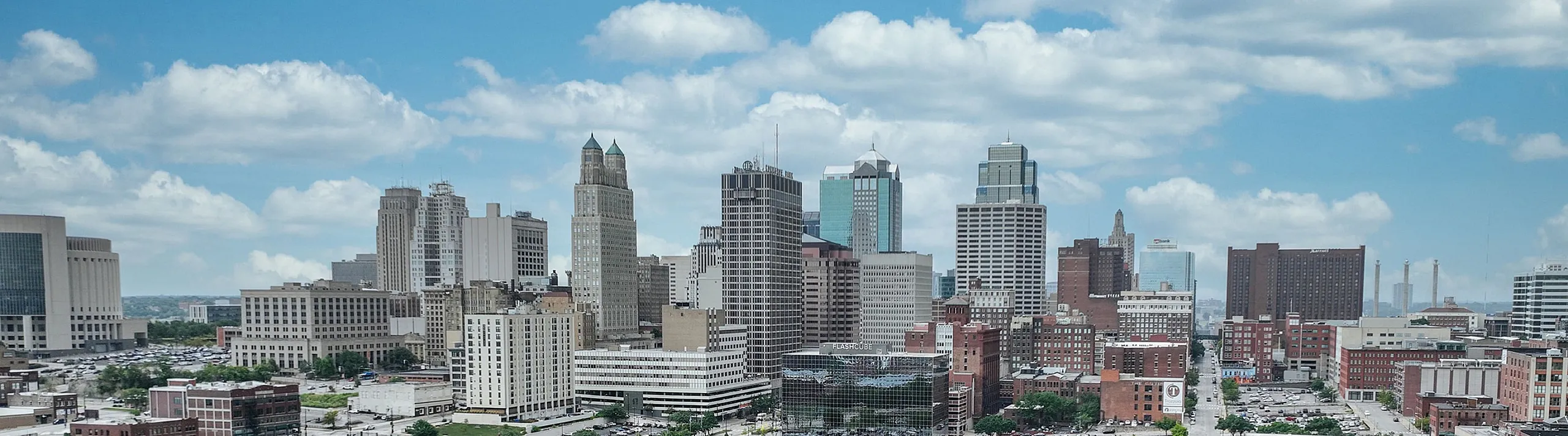 Beautiful aerial view of a vibrant urban skyline with diverse architecture under a bright blue sky.