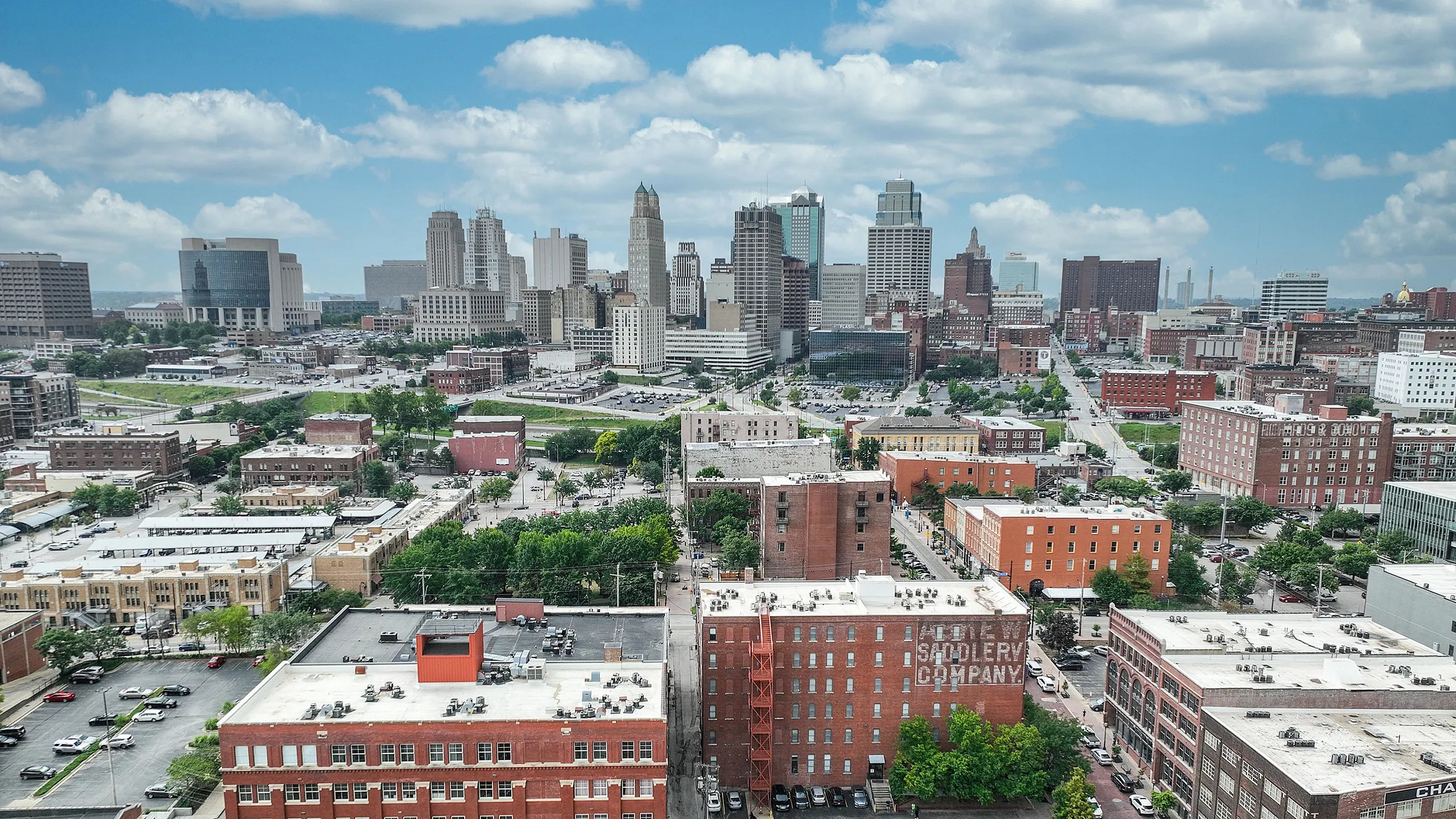Breathtaking cityscape view showcasing a vibrant downtown area with historic brick buildings and lush green spaces under a clear blue sky.
