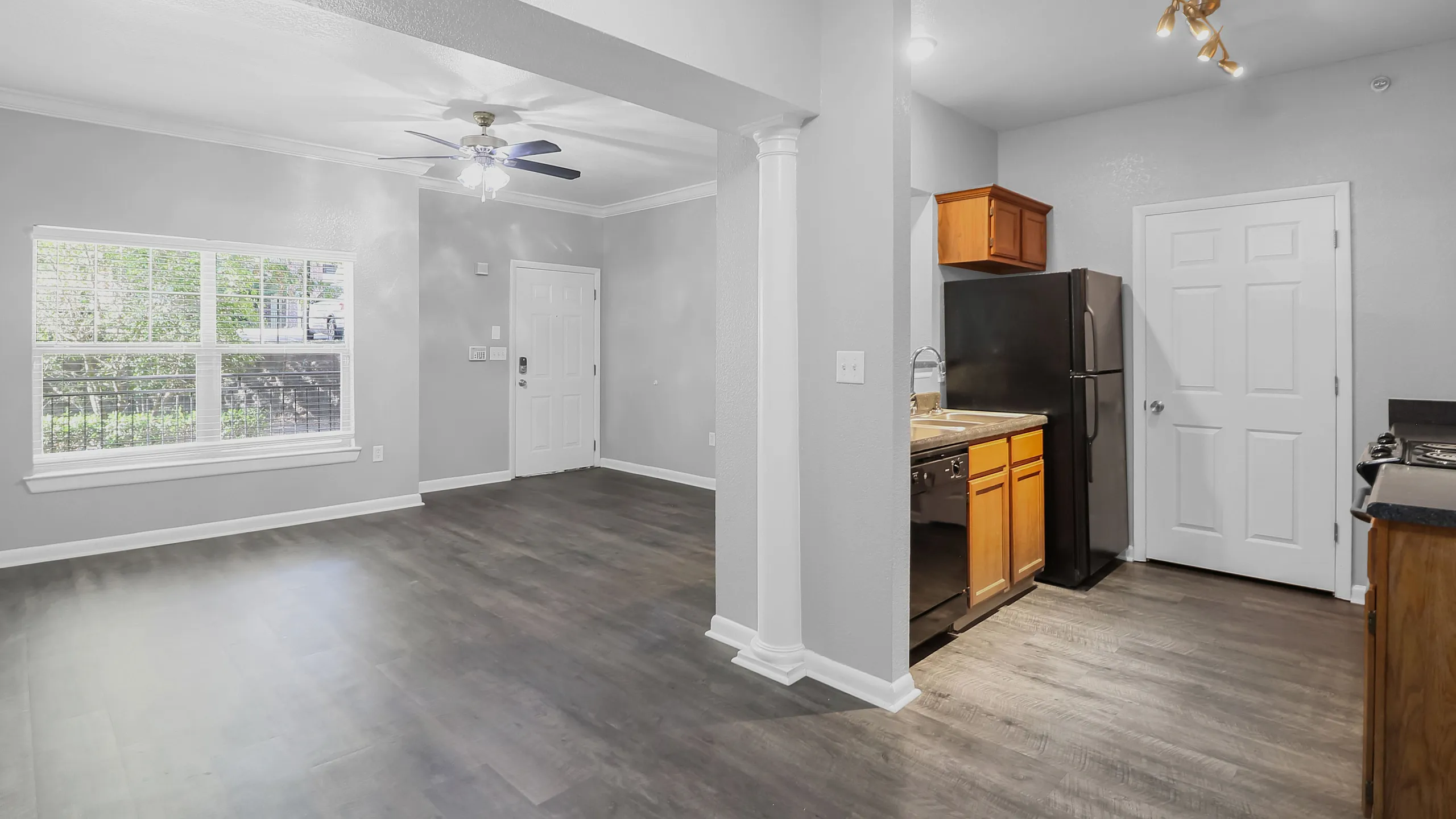 Bright modern apartment interior with spacious open-plan living area, elegant hardwood floors, and a sleek kitchen featuring stainless steel appliances.